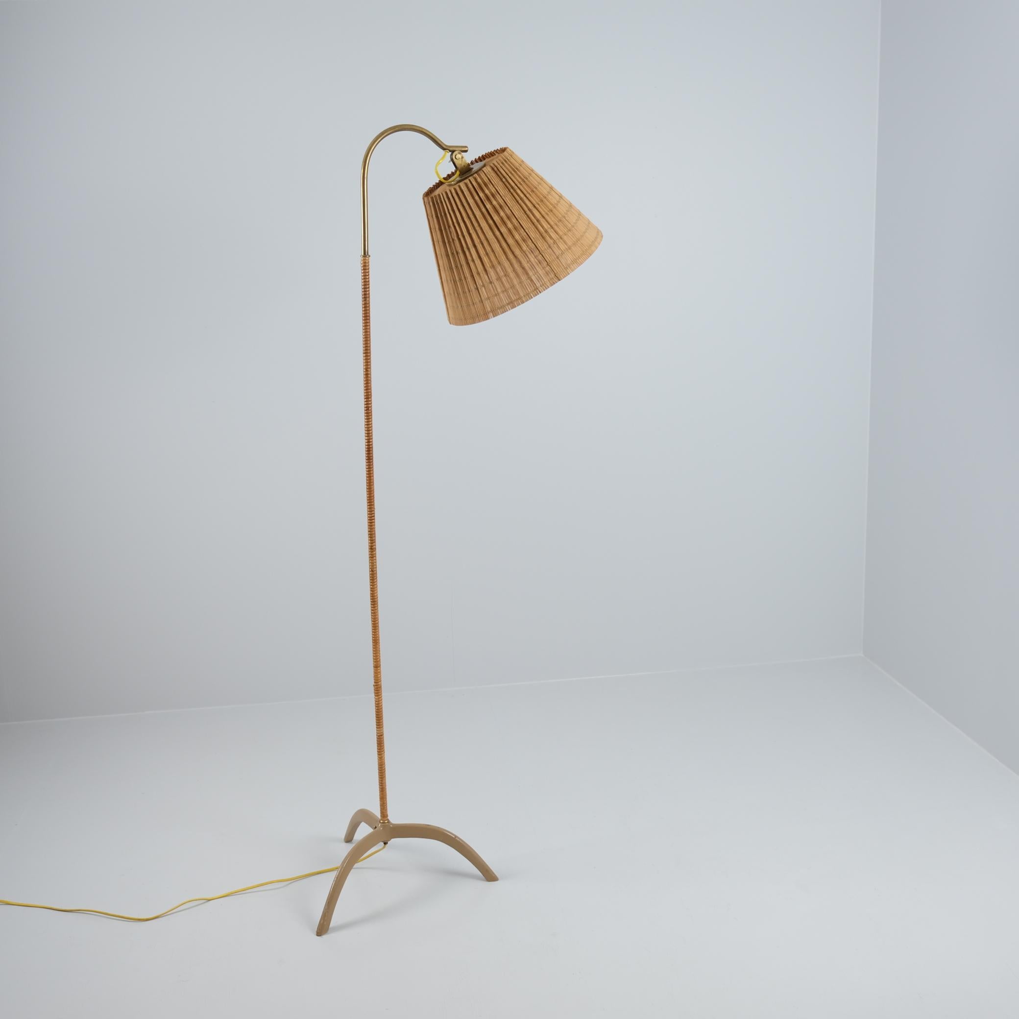 Lampadaire original Paavo Tynell modèle. 9609, fabriqué par Taito Oy dans les années 1950. Un magnifique lampadaire avec une tige en métal laqué et en rotin. Toutes les pièces sont d'origine, à l'exception du magnifique abat-jour en rotin renouvelé.