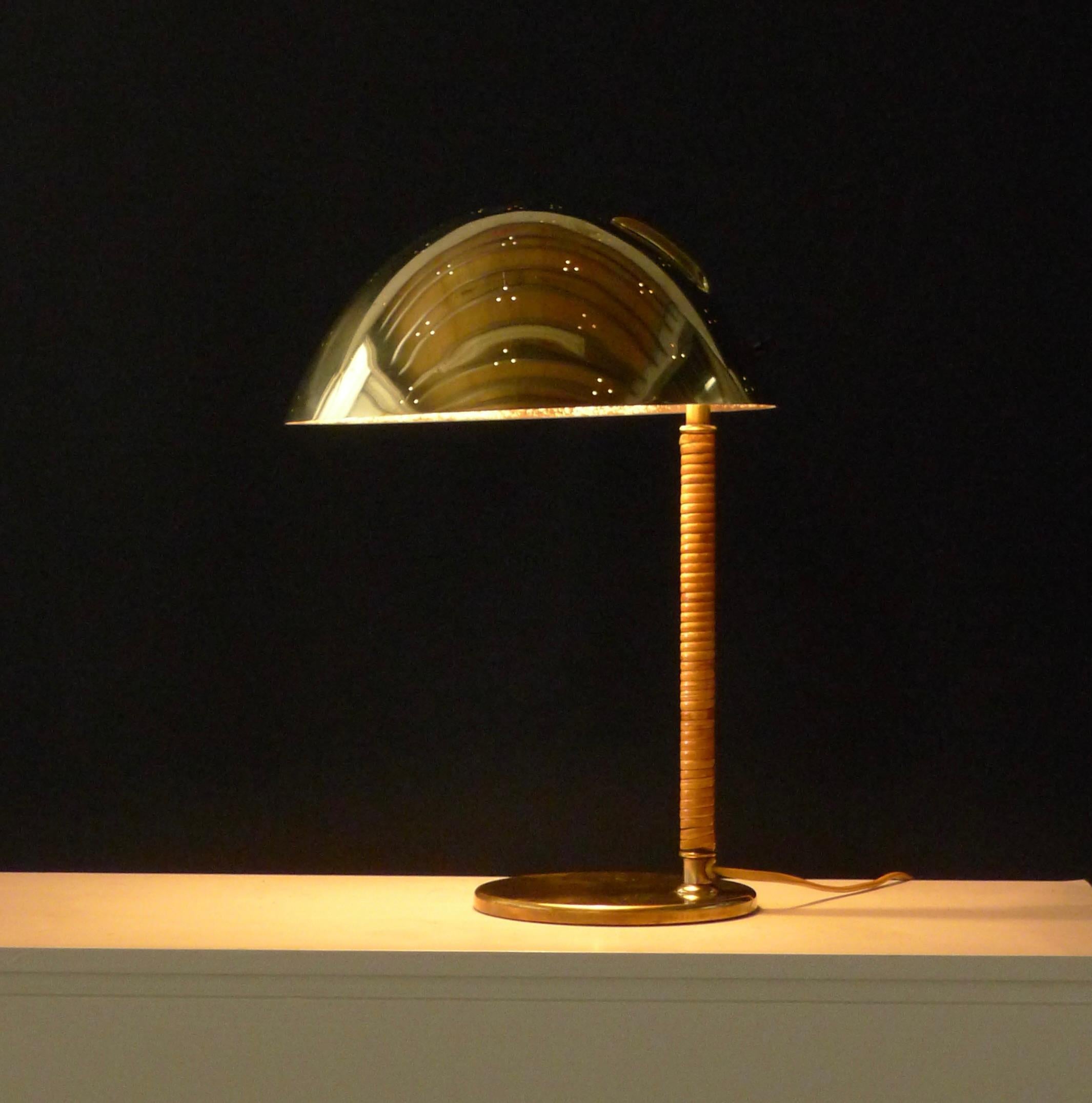 Paavo Tynell, Kypärä (or helmet) table lamp or desk light, model 9209, in brass with perforated domed shade and rattan wrapped stem, 40cm high, 26cm wide

The interior of the shade has been sprayed white at some point and there is speckling where it
