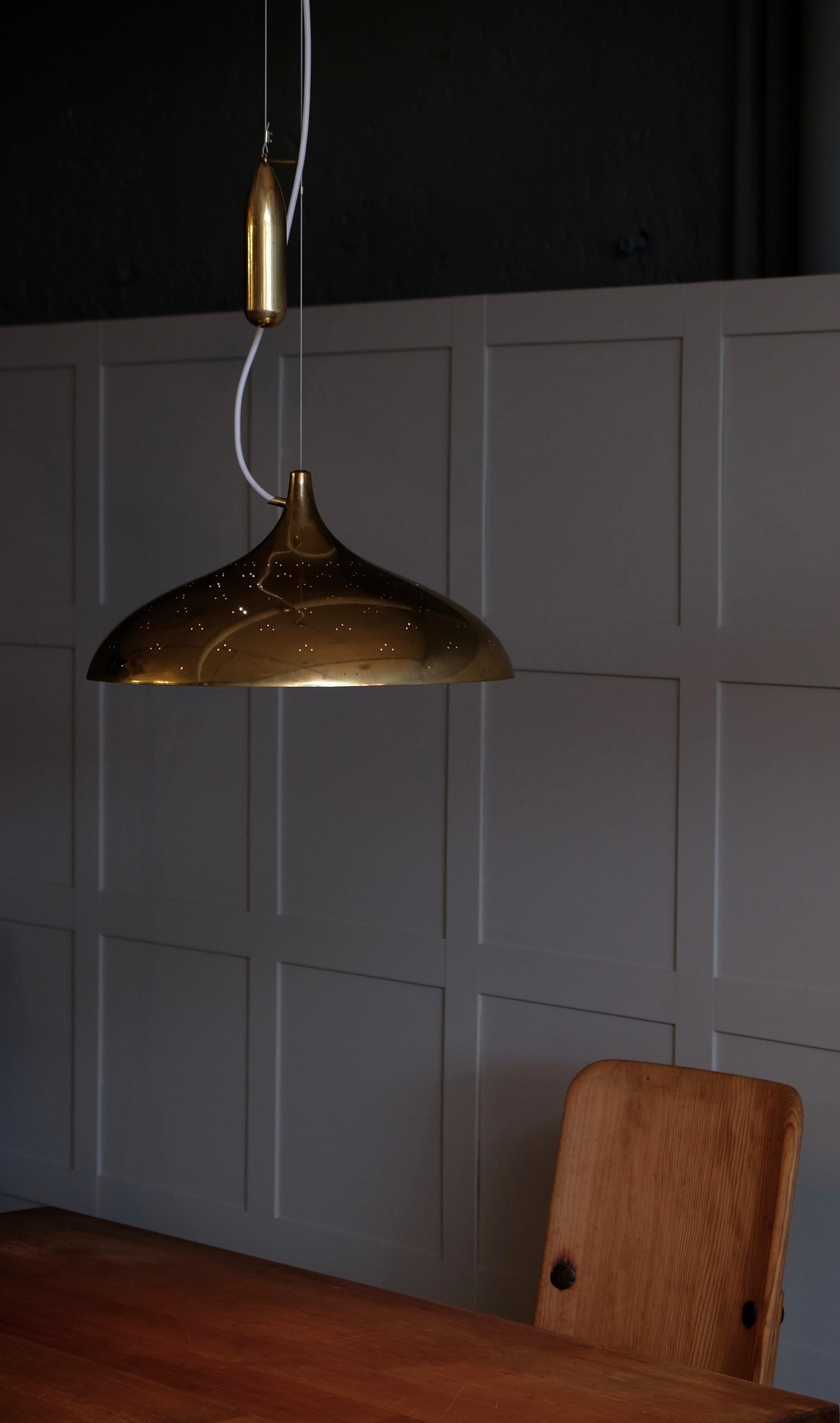 Paavo Tynell counter weight pendant in brass with perforated shade, paper diffuser with brass finial at center. The overall length is completely adjustable. Manufactured by Taito Oy. New wiring.
Finland, circa 1950s.