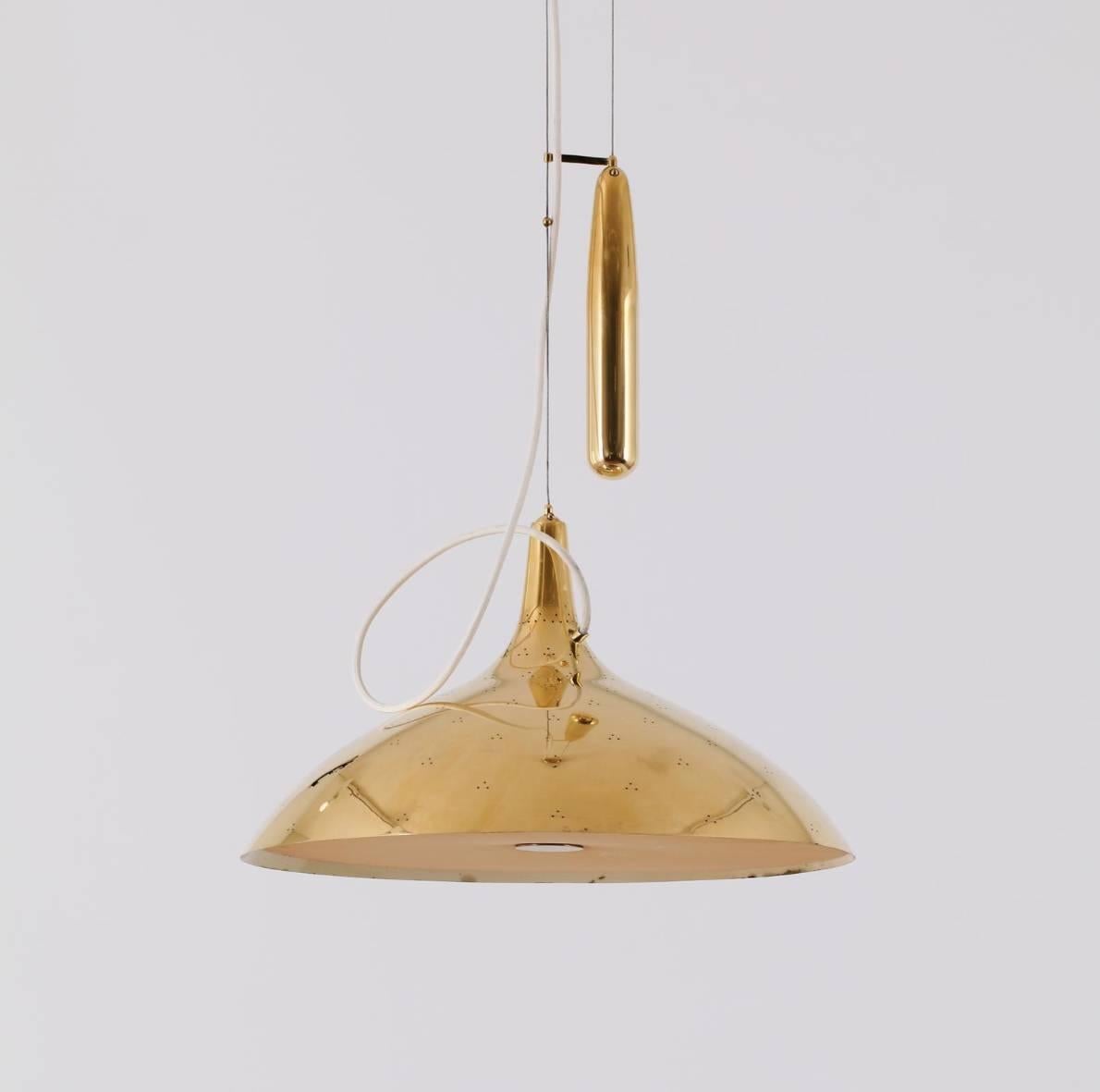 A very nice early example of the classic A1965 counter balance / elevating brass pendant lamp designed by Paavo Tynell for Taito Oy in the 1950s. Wonderful condition with the rare original nylon diffuser attached. Stamped with makers mark.