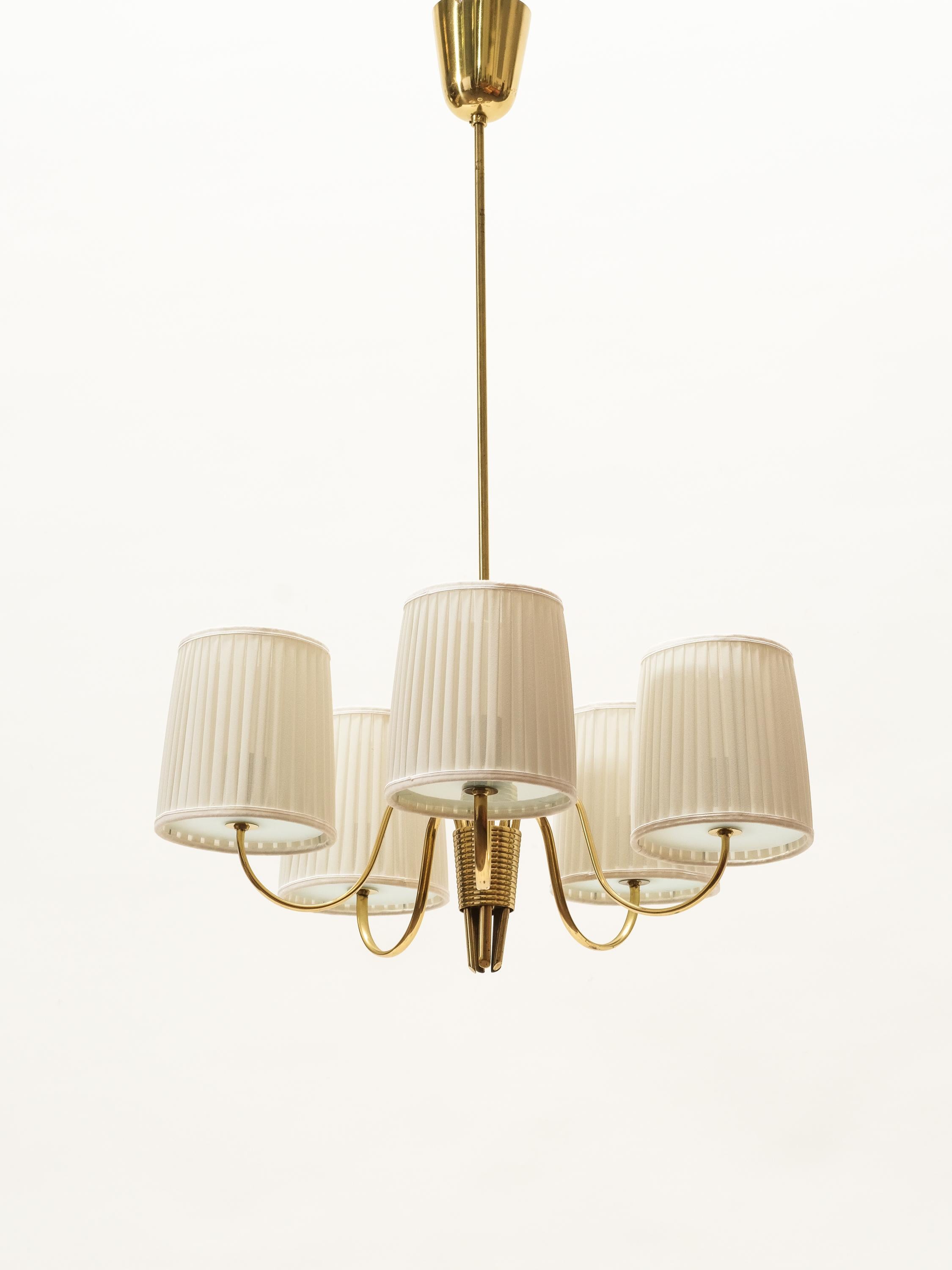 Wonderful and well made five-armed chandelier on a brass frame, frosted glass and new beautiful silk shades.

This is model 9031, designed by Paavo Tynell and made in Finland by Idman.

The lamp has been professionally rewired and in excellent
