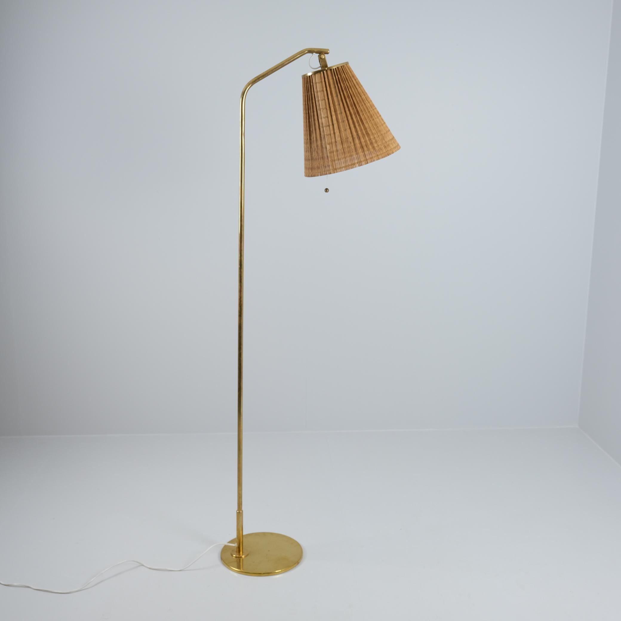 Una elegante lámpara de pie del maestro Paavo Tynell. Esta lámpara de pie minimalista, modelo 9613, desprende elegancia por su sencillez. El soporte de la pantalla es ajustable, lo que hace que esta lámpara sea perfecta para espacios de lectura,