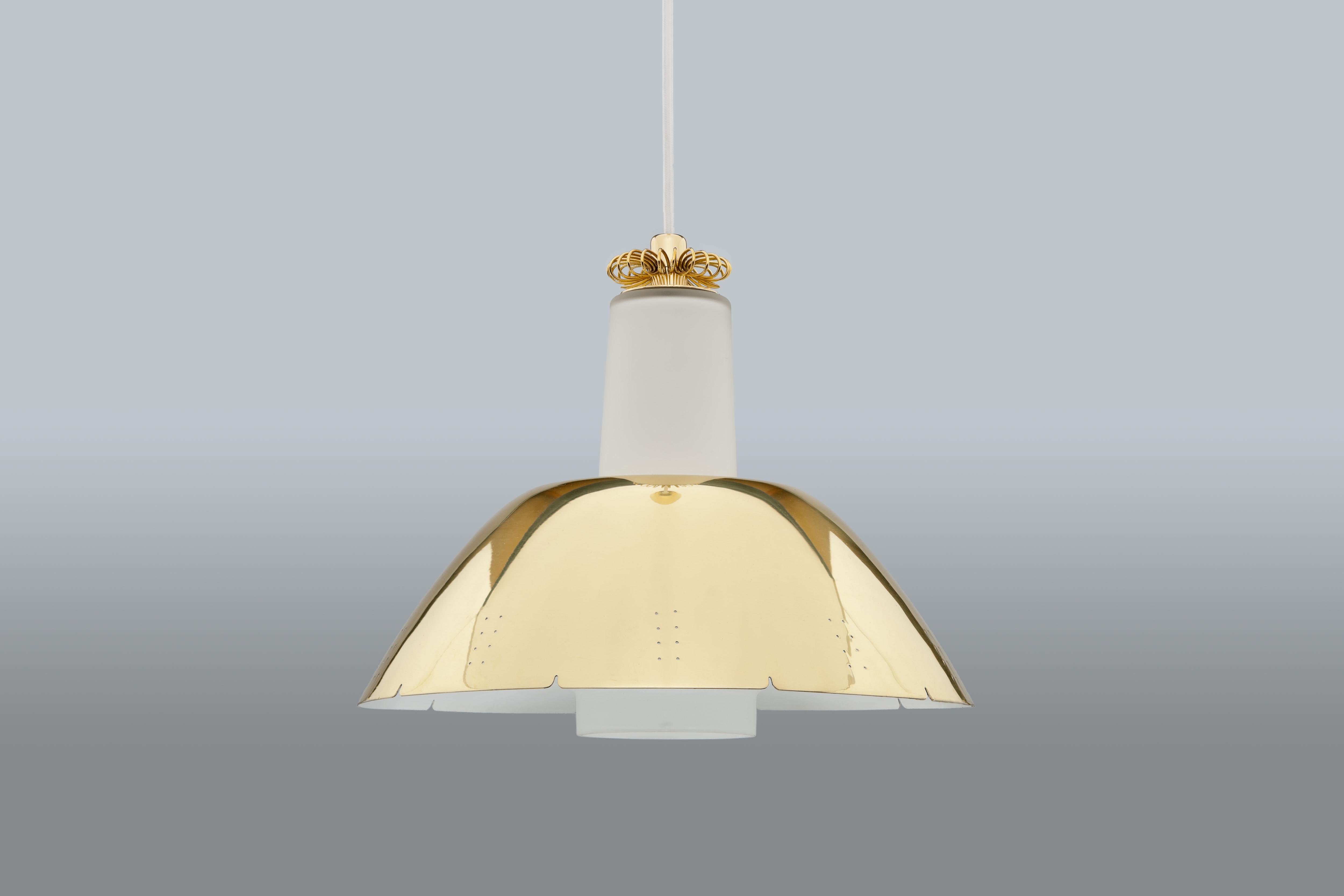 1950's brass and opal glass pendant model K2-20 by Paavo Tynell for Idman Oy Finland
Polished and perforated brass dome shaped shade over mouth blown frosted glass diffuser. 
A beautiful refined brass rosette flower detail is featuring on top of