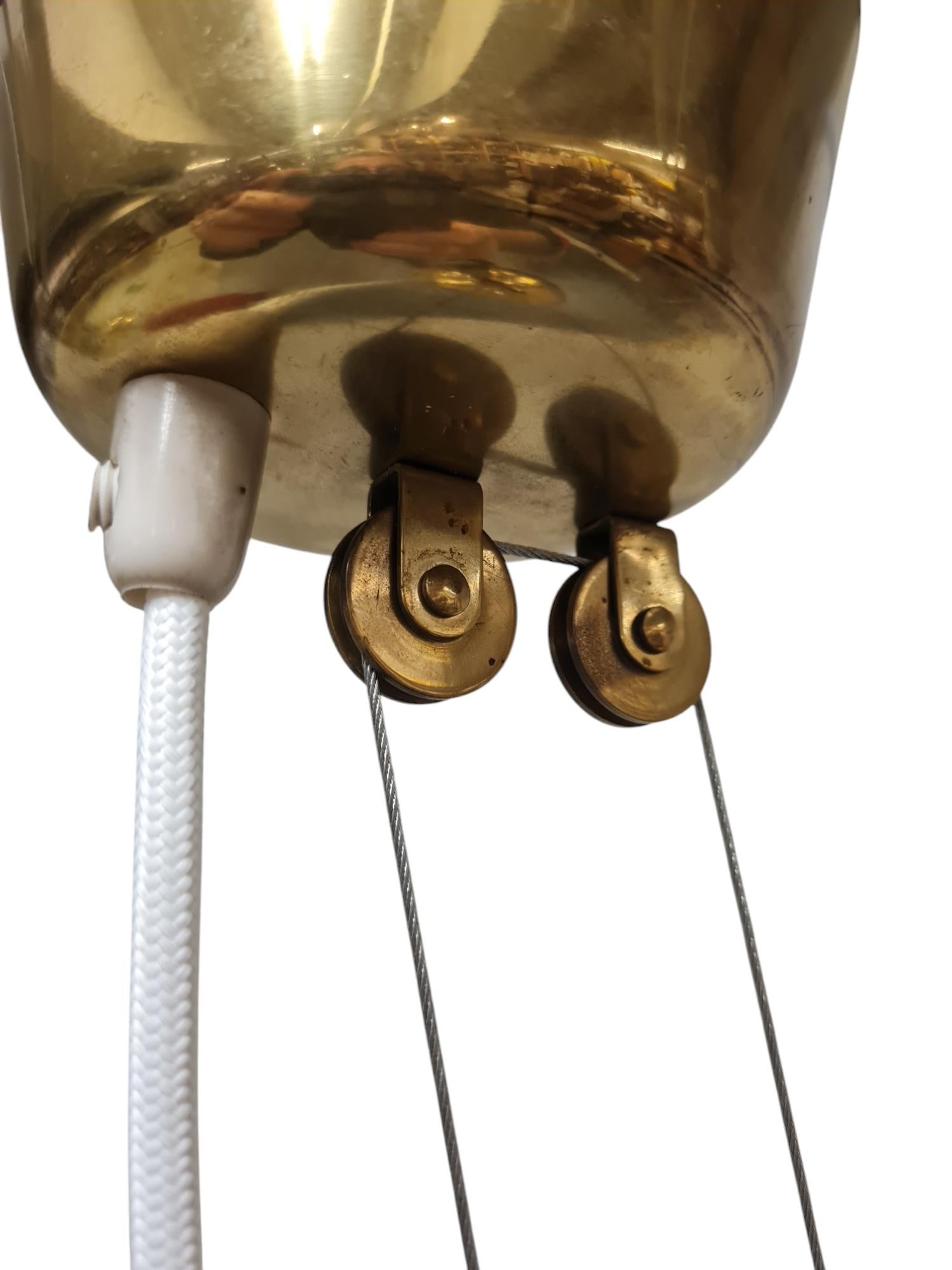 Paavo Tynell ha creato il design della lampada a contrappeso in risposta alle specifiche americane che non consentivano di appendere le lampade ai cavi elettrici. Il risultato fu un'intera serie di lampade a contrappeso di cui questo modello, il