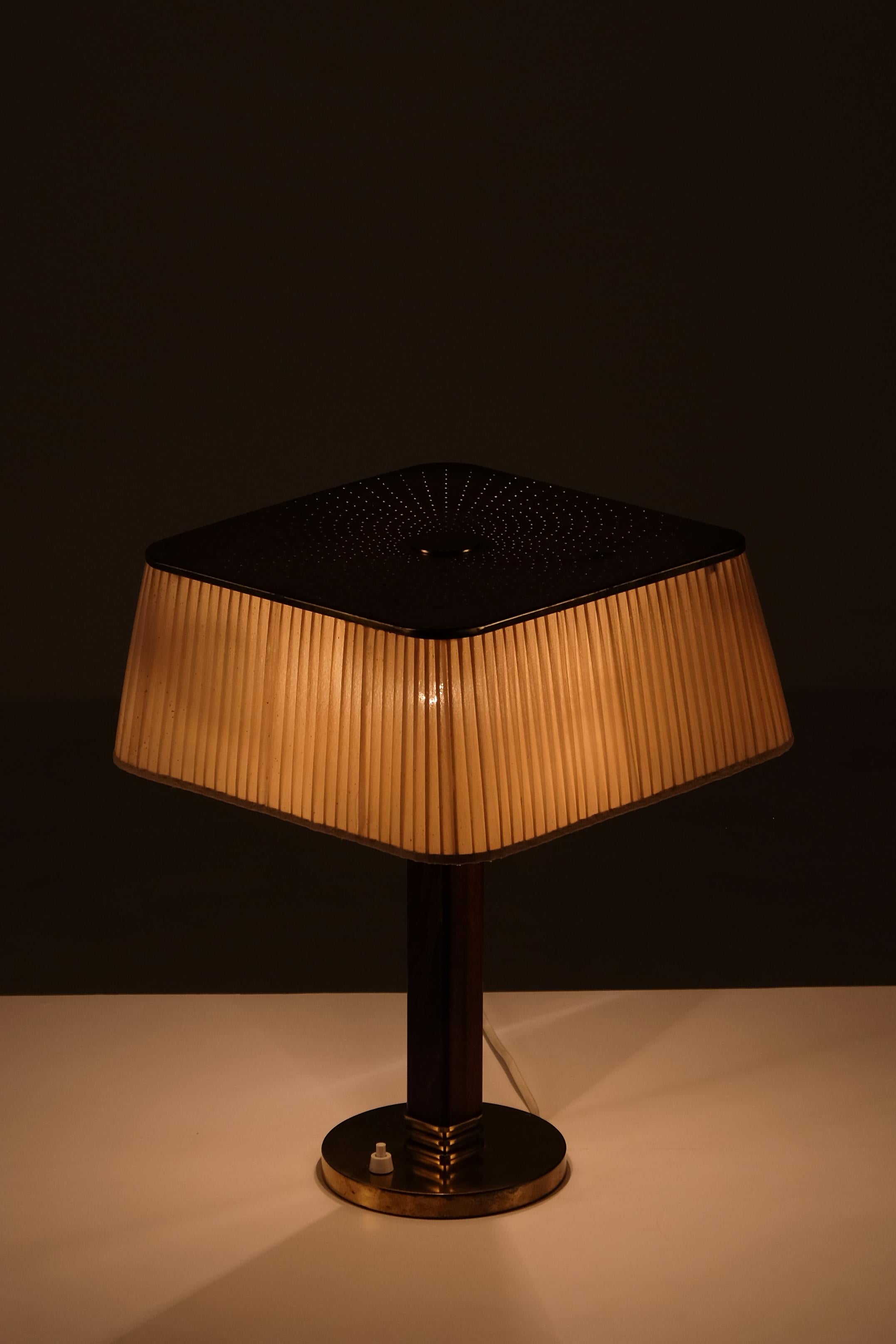 Paavo Tynell table lamp in brass with perforated shade. Manufactured by Taito Oy, Finland, circa 1940s.