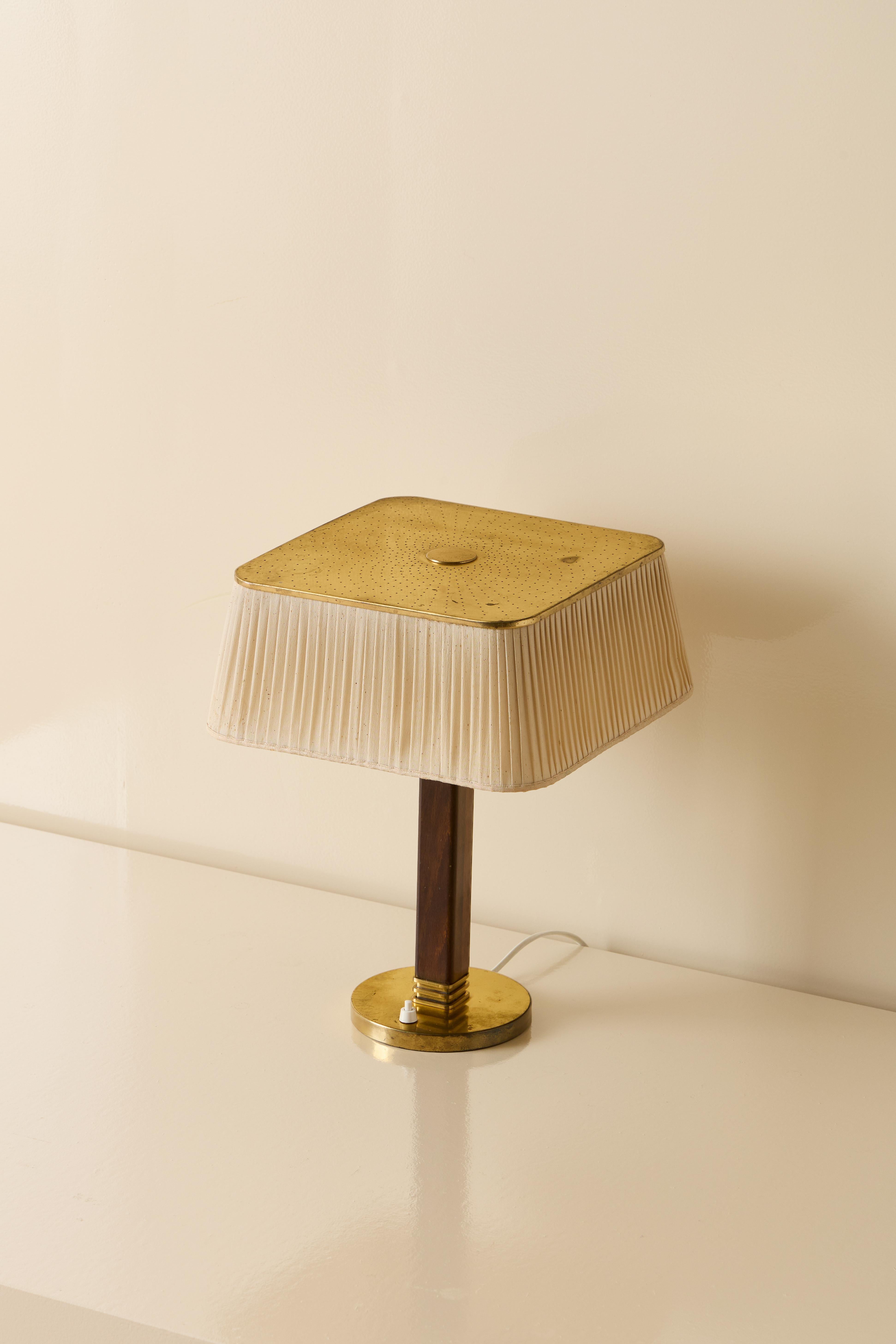 Paavo Tynell table lamp in brass with perforated shade. Manufactured by Taito Oy, Finland, circa 1940s.