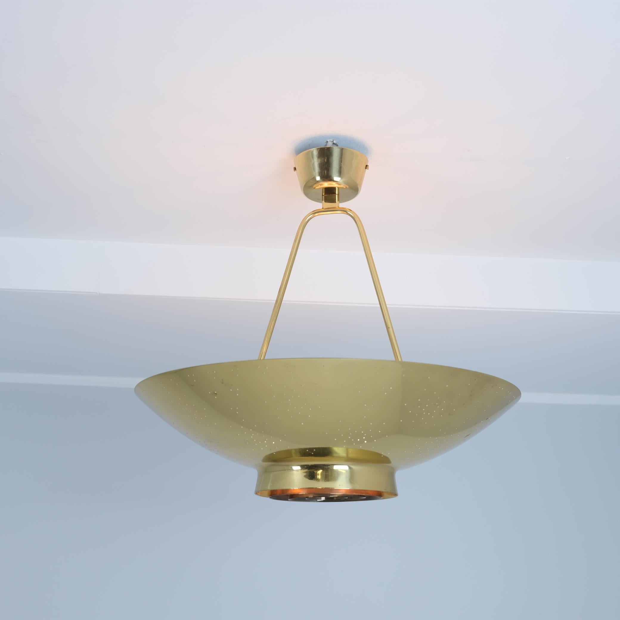 Lampada da soffitto Paavo Tynell modello 9060, alias la lampada UN prodotta da Idman in Finlandia negli anni Cinquanta. La lampada ha un design brillante con lamelle circolari centrali che riprendono il logo dell'ONU e sono abbracciate dal