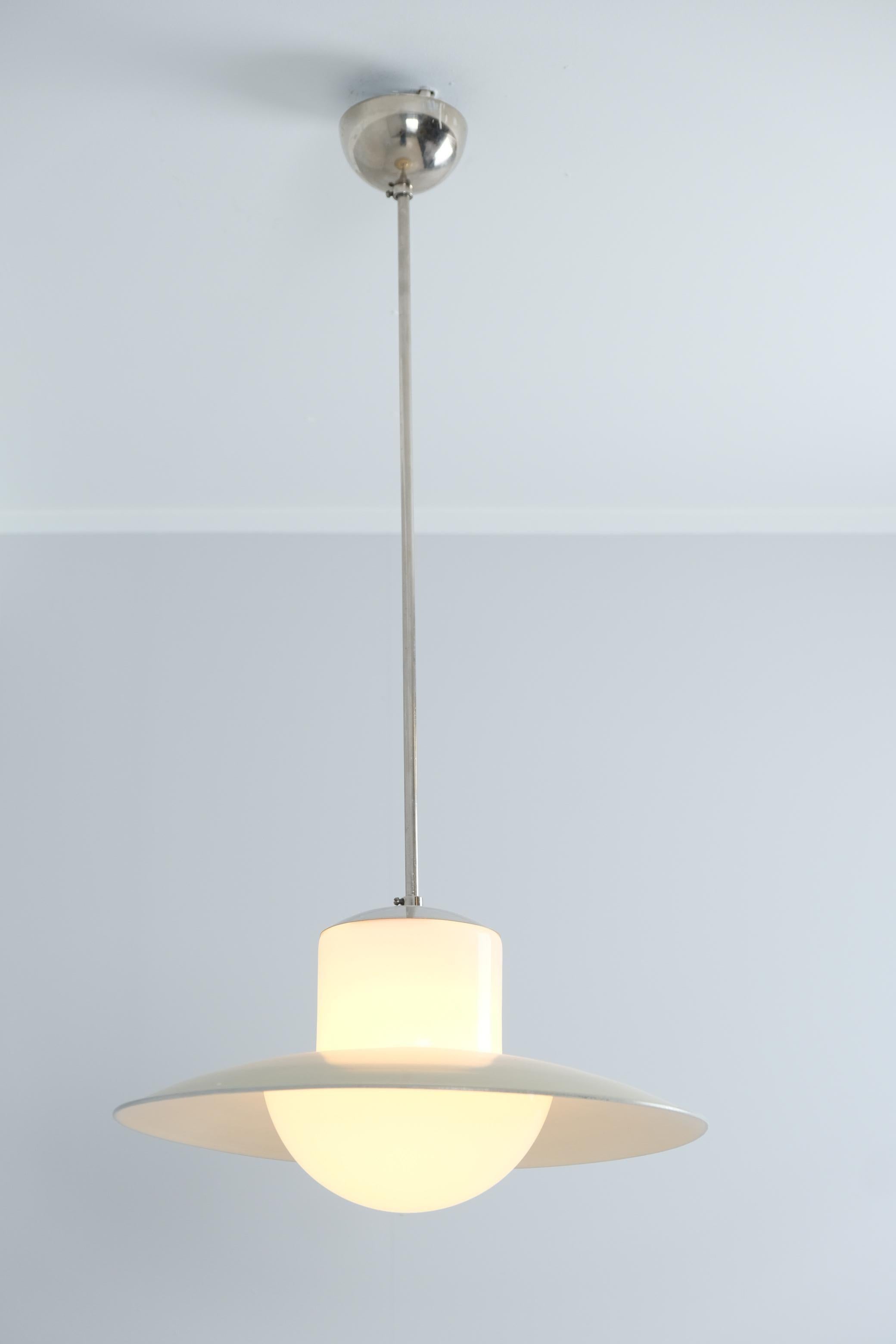 Lampada minimalista del Mid-Century Modern di Paavo Tynell prodotta da Idman negli anni '50. La lampada presenta un corpo cromato con un paralume in vetro opalino a forma di campana sormontato da un paralume in metallo verde Greene & Greene. La