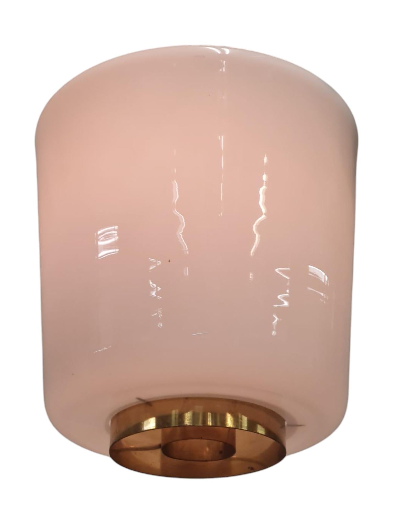 A minimalist mid-century modern flushmount by Paavo Tynell in Opaline glass and brass details. A very simplistic design that adds a modernist statement to any interior. Perfect for hallways, small spaces, entrances, or even bathrooms and kitchens.