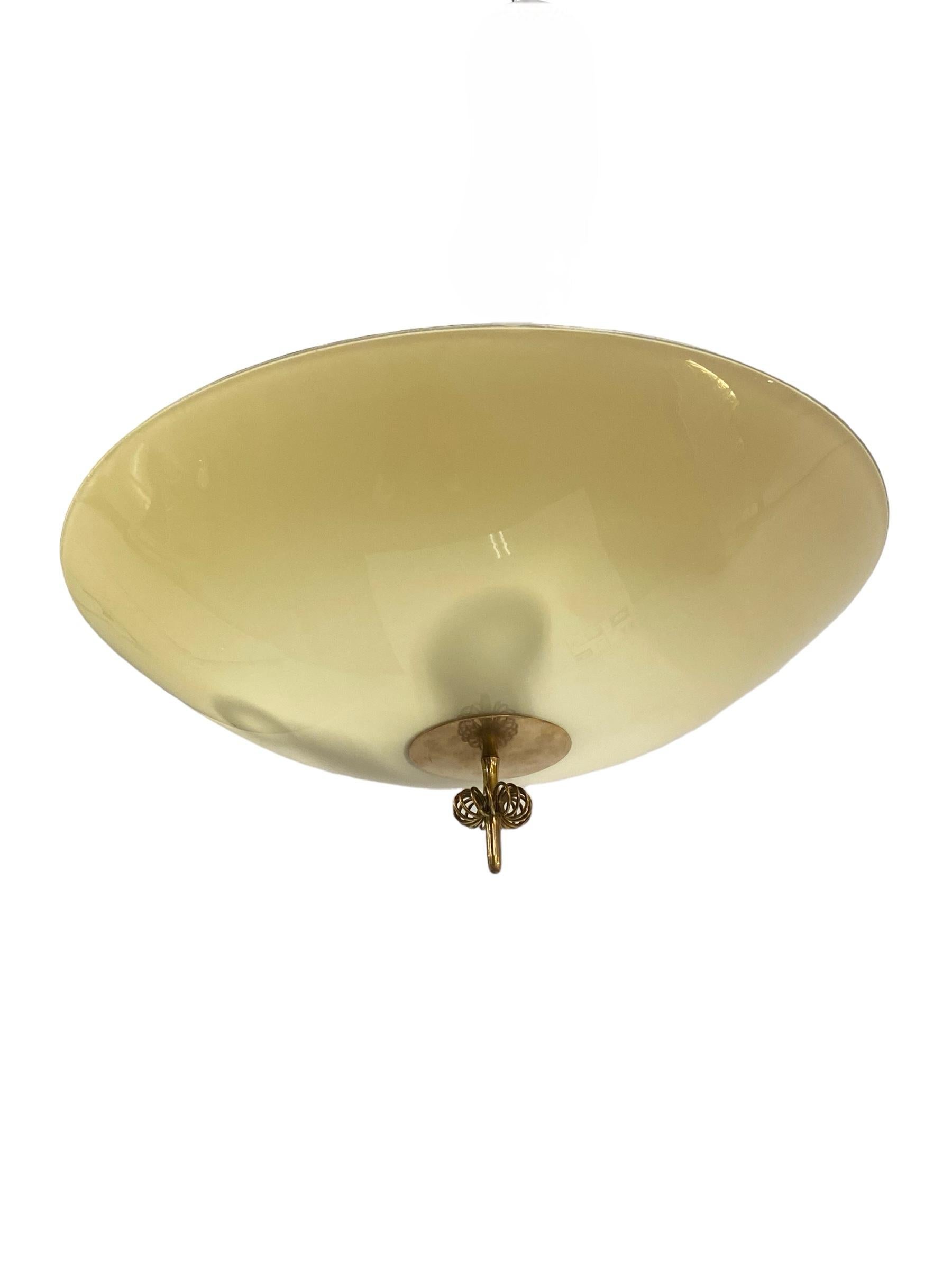 A beautiful ceiling lamp by Paavo Tynell. This model flush mount came with different size glass/fabric version shades, mainly 40,45,50,55 or 60 cm long, and 3 light bulbs. As most models this also came with a stem which would make into a pendant.