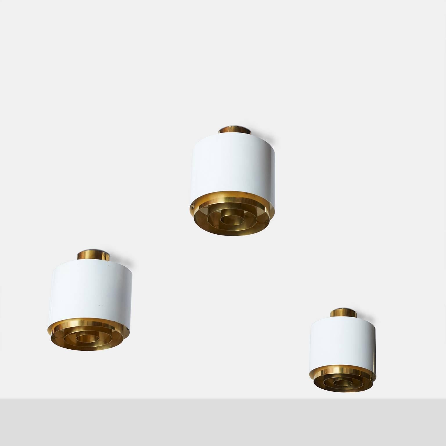 A rare and elegant set of three large white Paavo Tynell flush mounts with brass rings and brass ceiling caps for Idman. Sold individually. Can be either ceiling mount or hang as pendants.
Finland, circa 1950s.