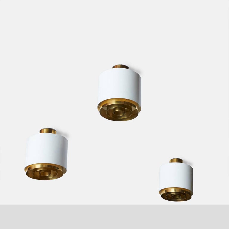 A rare and elegant set of three large white Paavo Tynell flush mounts with brass rings and brass ceiling caps for Idman. Sold individually. Can be either ceiling mount or hang as pendants.
Finland, circa 1950s.