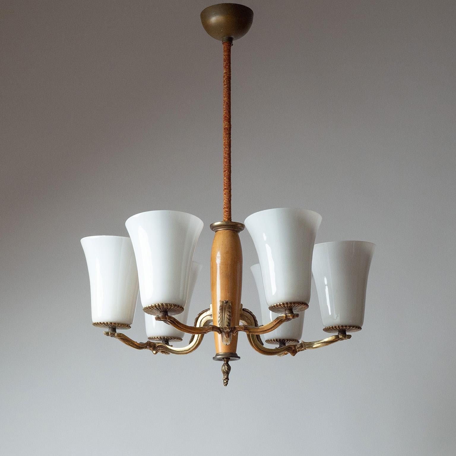 Lampadario Paavo Tynell modello 1855/6 degli anni Trenta. Snello centrotavola in legno con tre rami in ottone fuso a doppio braccio, ciascuno con un diffusore in vetro soffiato alto e affusolato. In buone condizioni originali, con patina sull'ottone