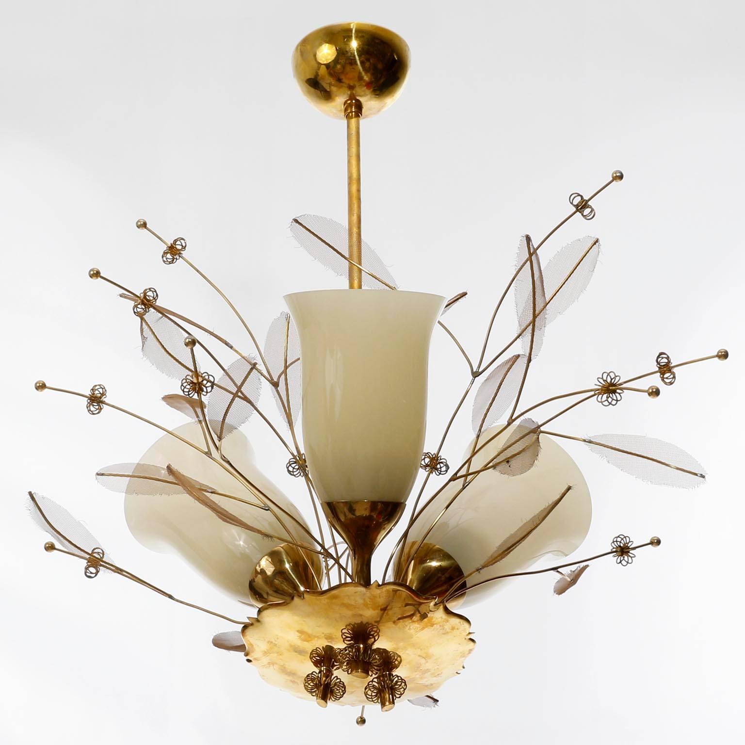 A rare ceiling light fixture model 9029 designed by Paavo Tynell and manufactured by Taito in Finland in 1950s.
The lamp is made of brass with floral decorations and three original opal glass shades in a champagne tone.
This wonderful chandelier