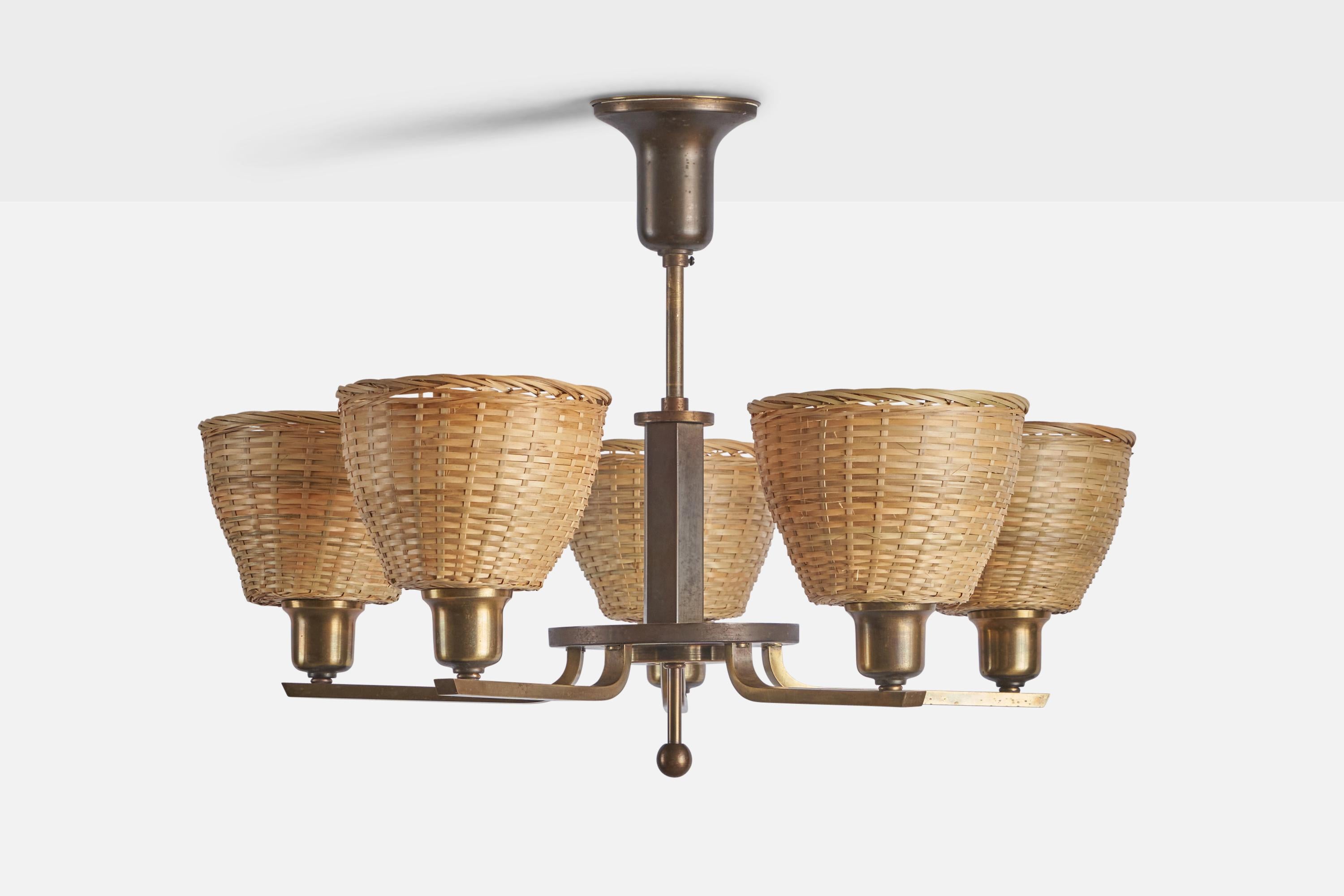 A brass and rattan chandelier, designed by Paavo Tynell and produced by Taito OY, Finland, 1940s.

Overall Dimensions (inches): 18.5” H x 25” Diameter
Bulb Specifications: E-26 Bulb
Number of Sockets: 5
Assorted rattan lampshades