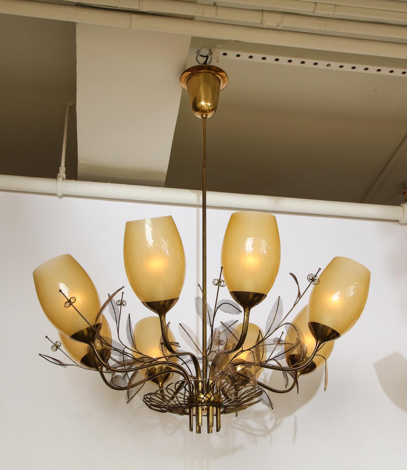 Rare Paavo Tynell 8-light chandeliers. Model #9029/8, brass structures with unusual detailing and brass-mesh leaves. Each chandelier features 8 arms ending with a standard edison socket surrounded by original gold-hued glass shades. This fixture has