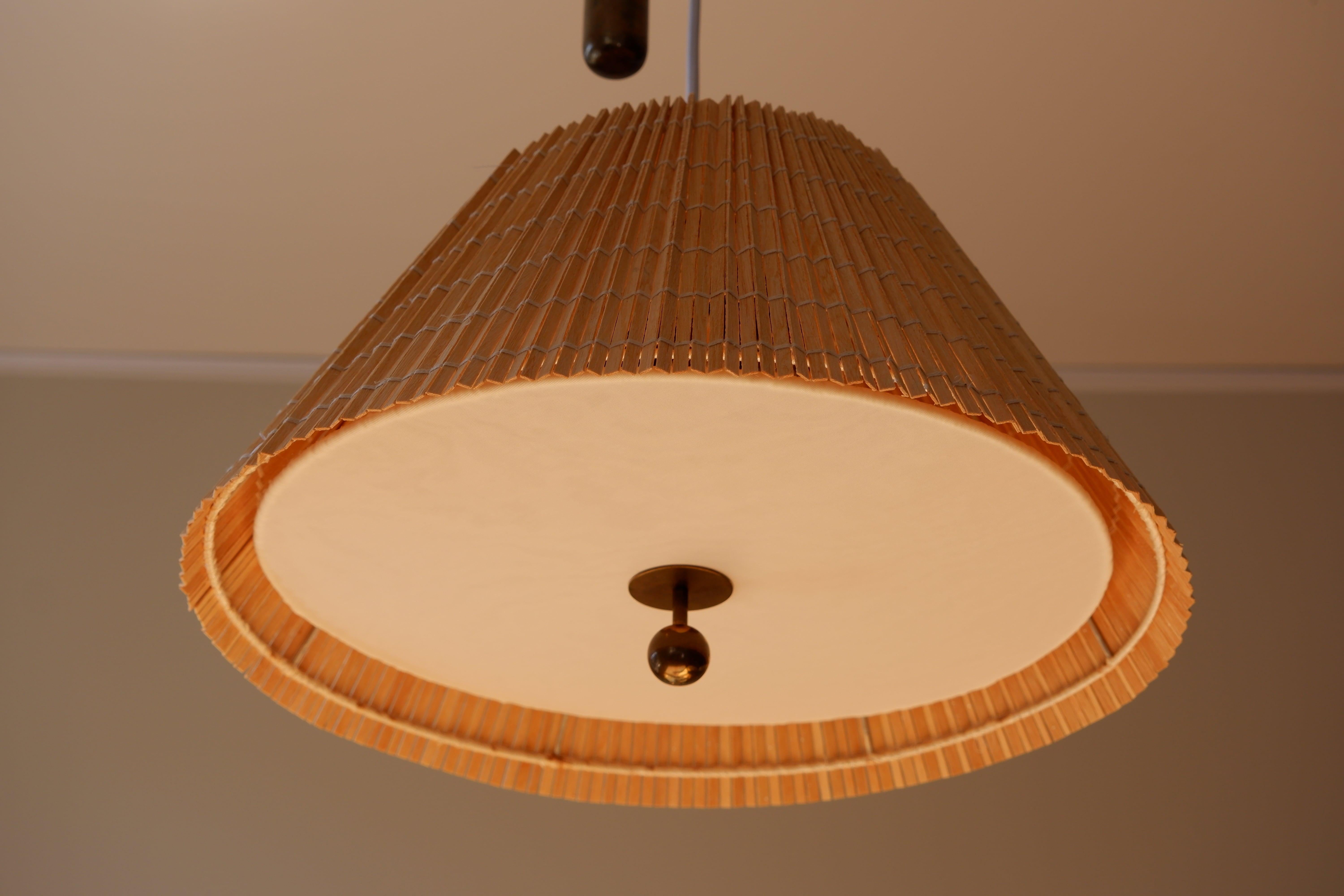 Counter Weight ceiling light model 1968 designed by Paavo Tynell and produced by TAITO OY in the 40's. The lamp is composed of a counterweight mechanism that goes up and done. The rattan shade has been restaured. Underneath you'll find a brass