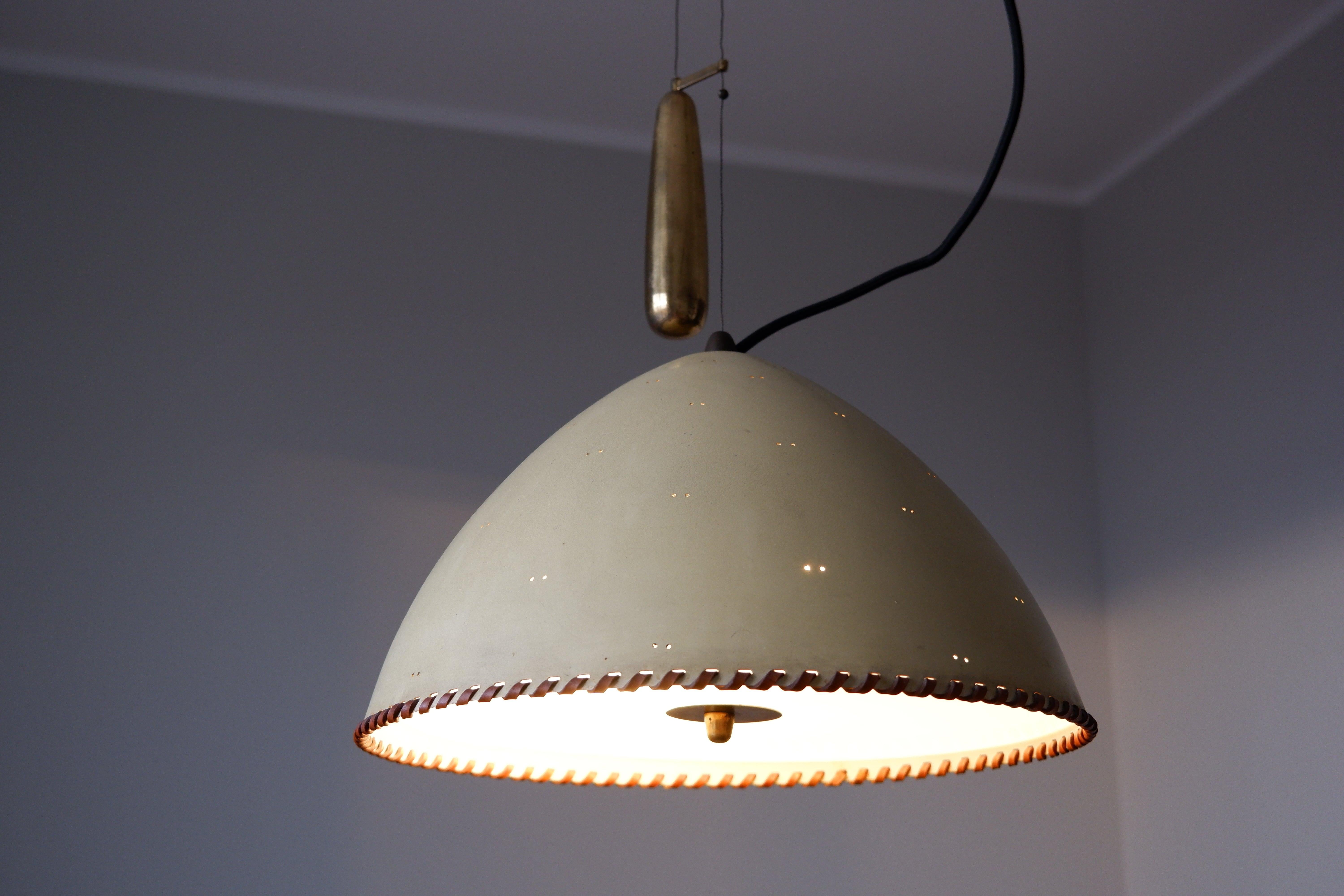 Rarissima lampada a sospensione modello A 1983 disegnata da Paavo Tynell negli anni '40 e prodotta da TAITO OY nello stesso periodo. La lampada ha il paralume originale dipinto, con un cerchio di pelle arrotondato sul fondo. Il sistema di