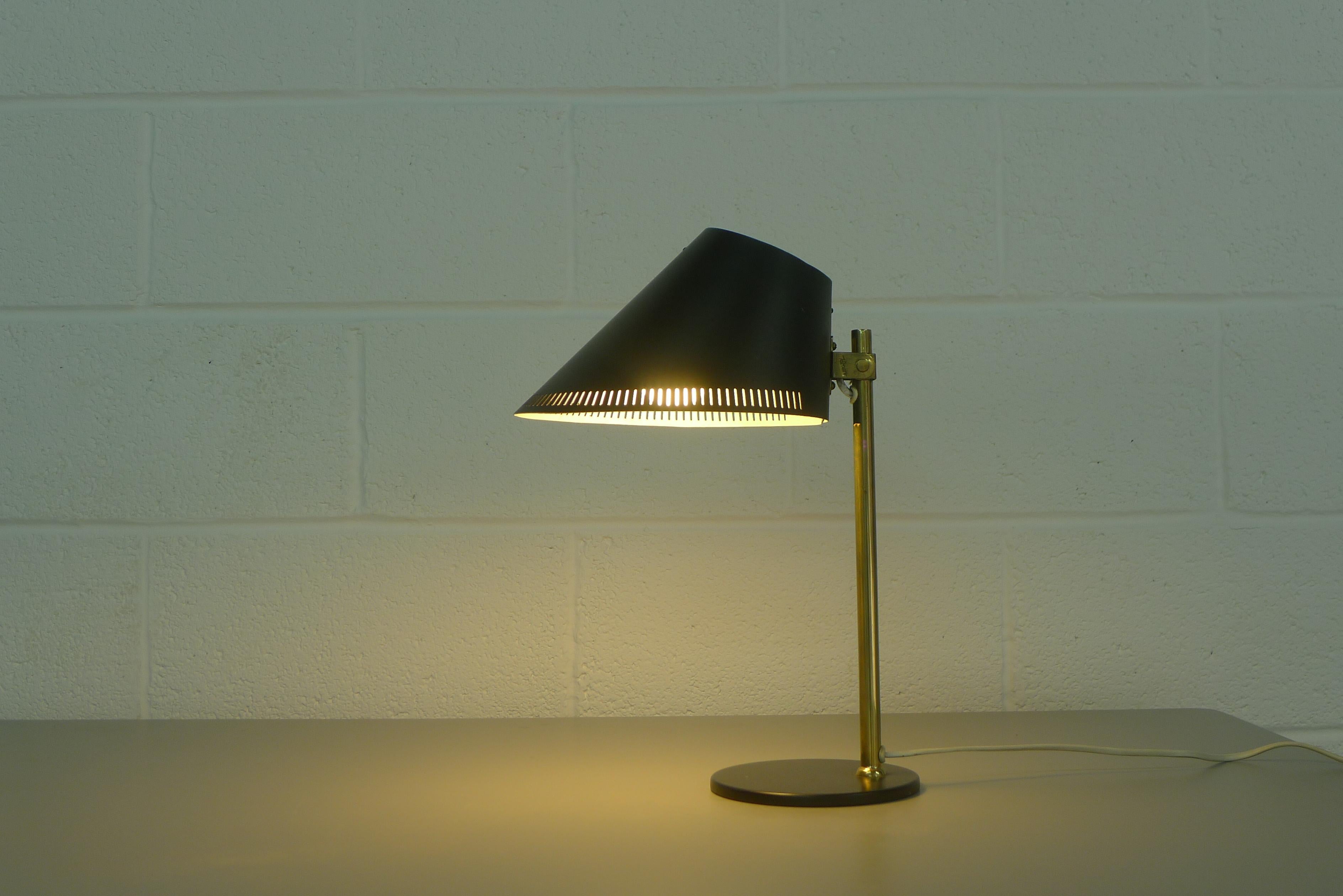 Paavo Tynell desk lamp model 9227 designed in the 1950s for Idman. Black base and black enameled perforated shade joined by brass staem with pivot mechanism allowing the shade to articulate. Signed on the stem bracket.