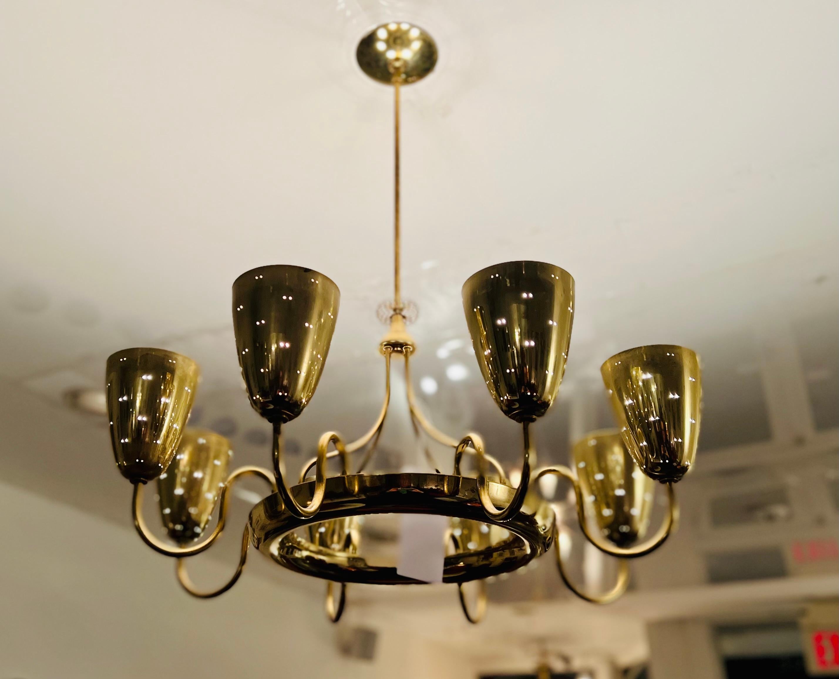 Versione a otto bracci, interamente in ottone, dell'iconico lampadario 