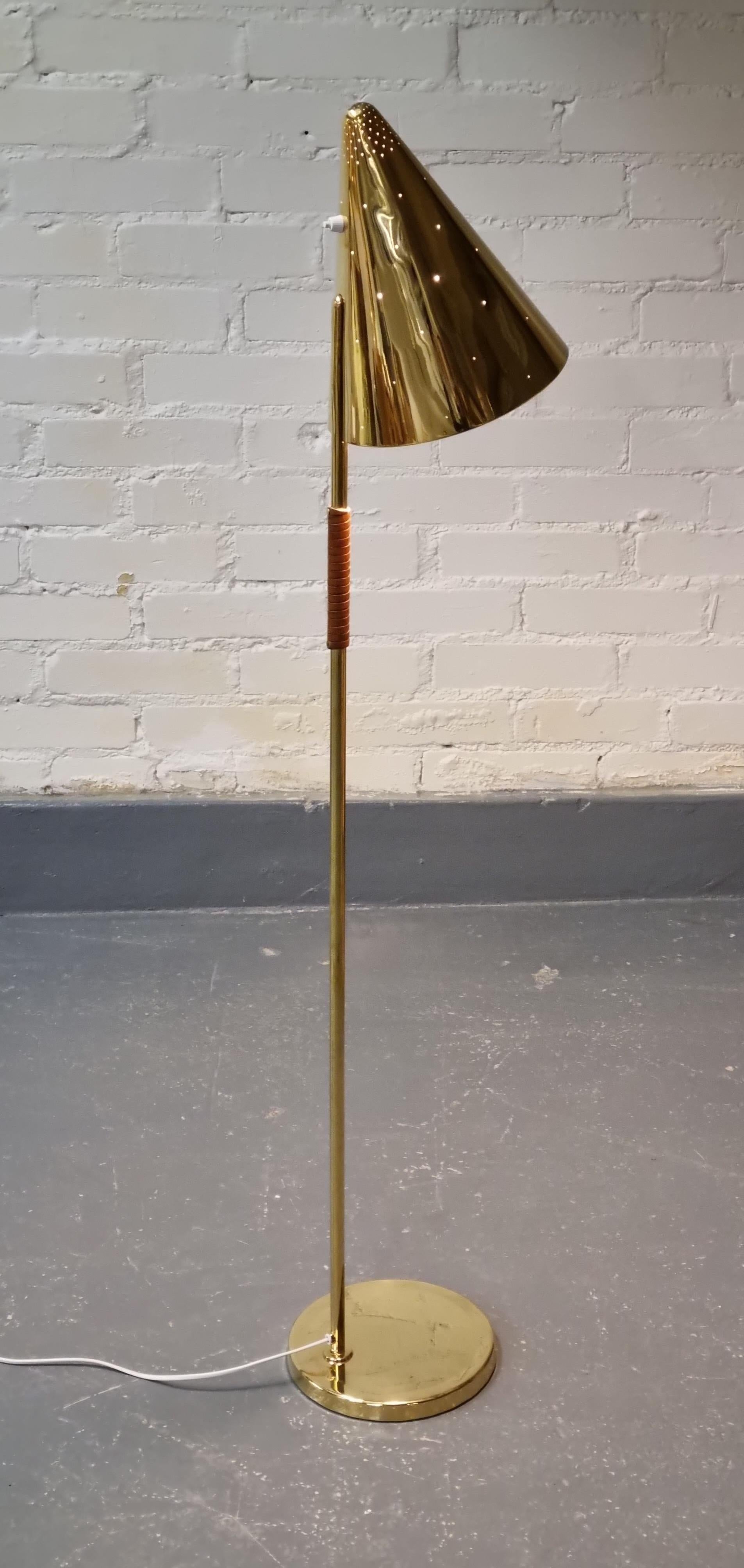 A magnificent and extremely rare floor lamp model 9624 by Paavo Tynell (1890-1973) from 1950s in a beautiful vintage condition.

The shade is cone shaped, perforated and has the switch on the back side. The brass stem is partly coated with brown