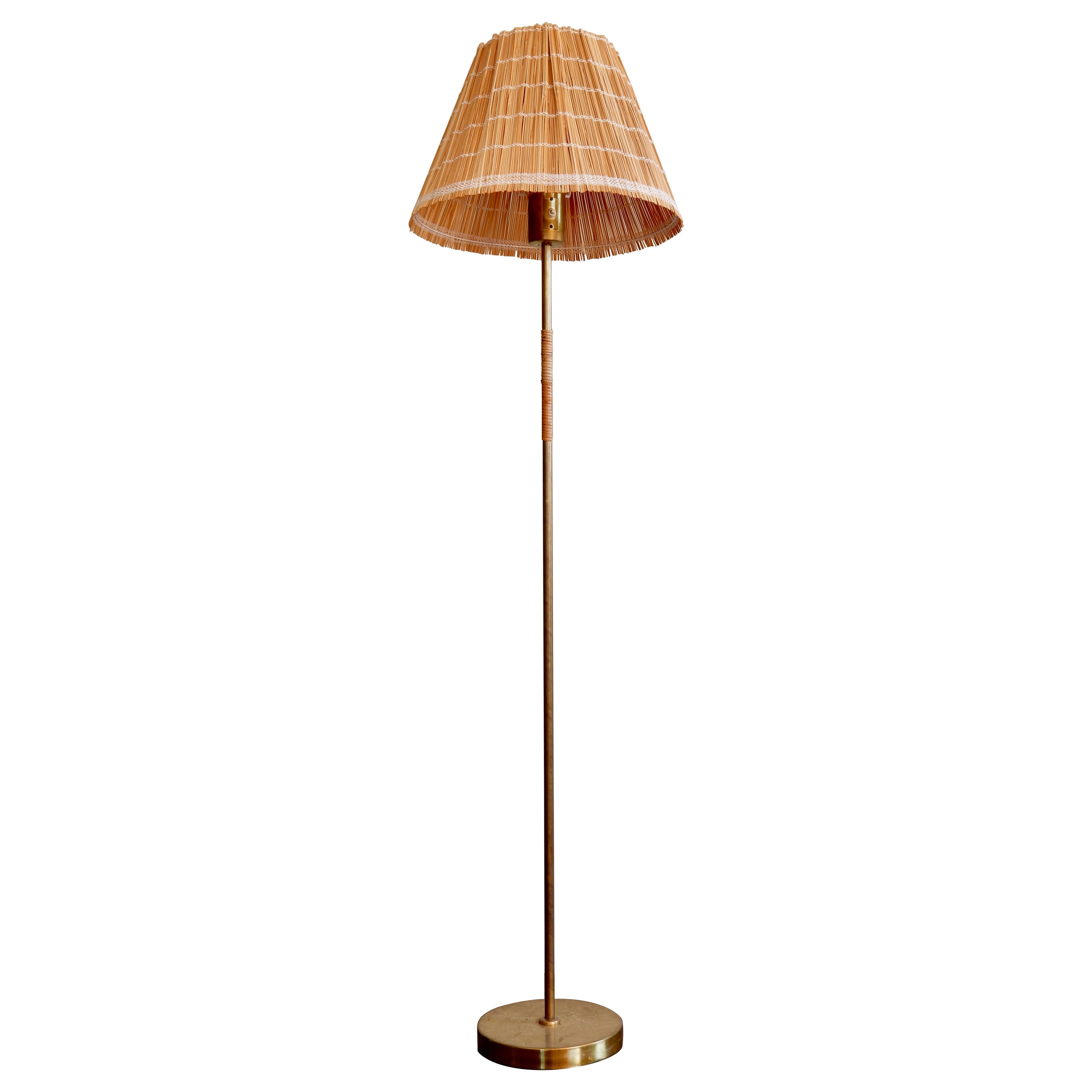 Lampada da terra Paavo Tynell modello K10-13 per Idman del 1950 circa, ottone e rattan.