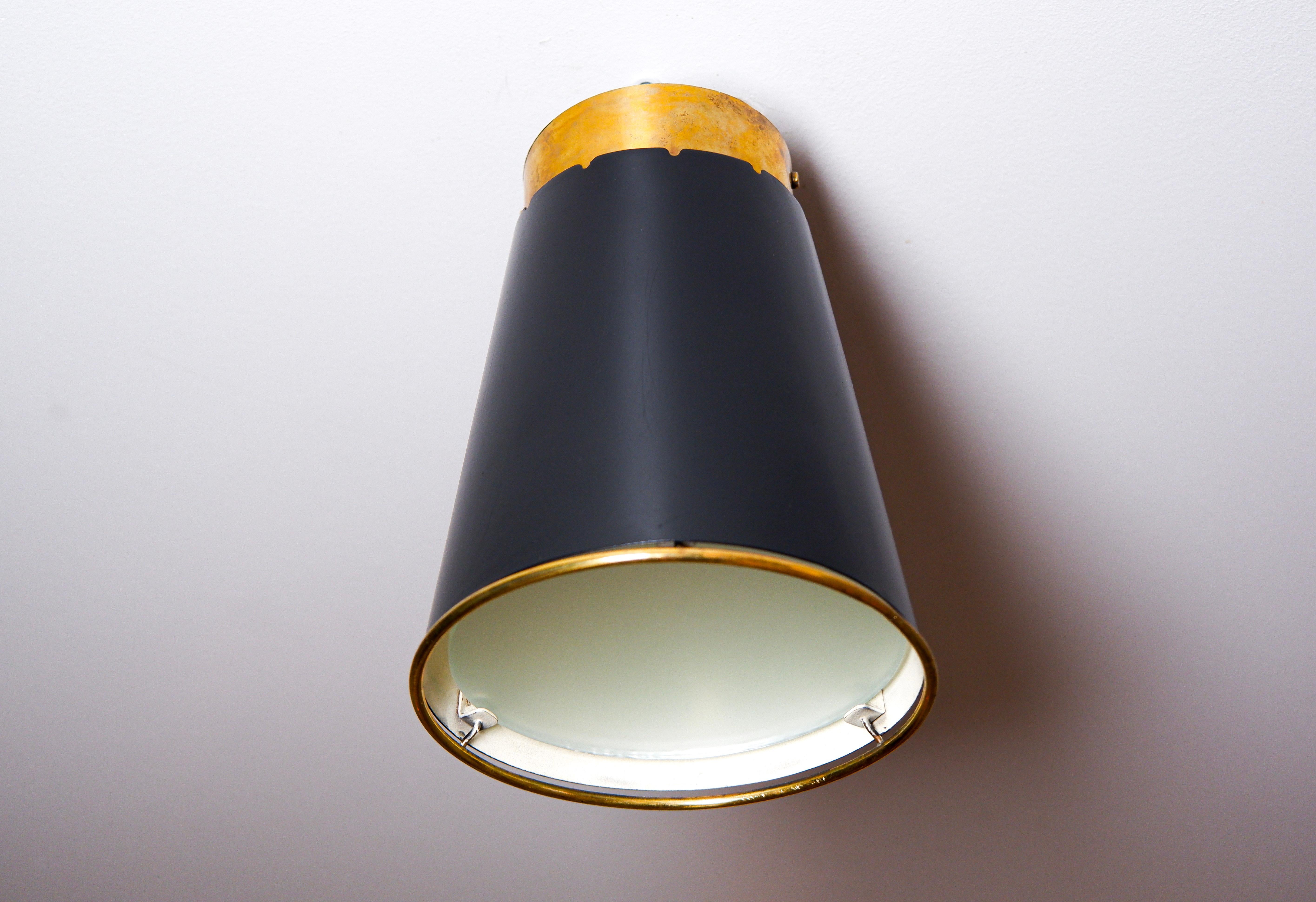 Schöne Unterputzdose von Paavo Tynell aus den 50er Jahren. Die Leuchte besteht aus einem schwarz lackierten Eisenkern mit Messingverzierung und einem Glasdiffusor. Guter Zustand der Halle. 