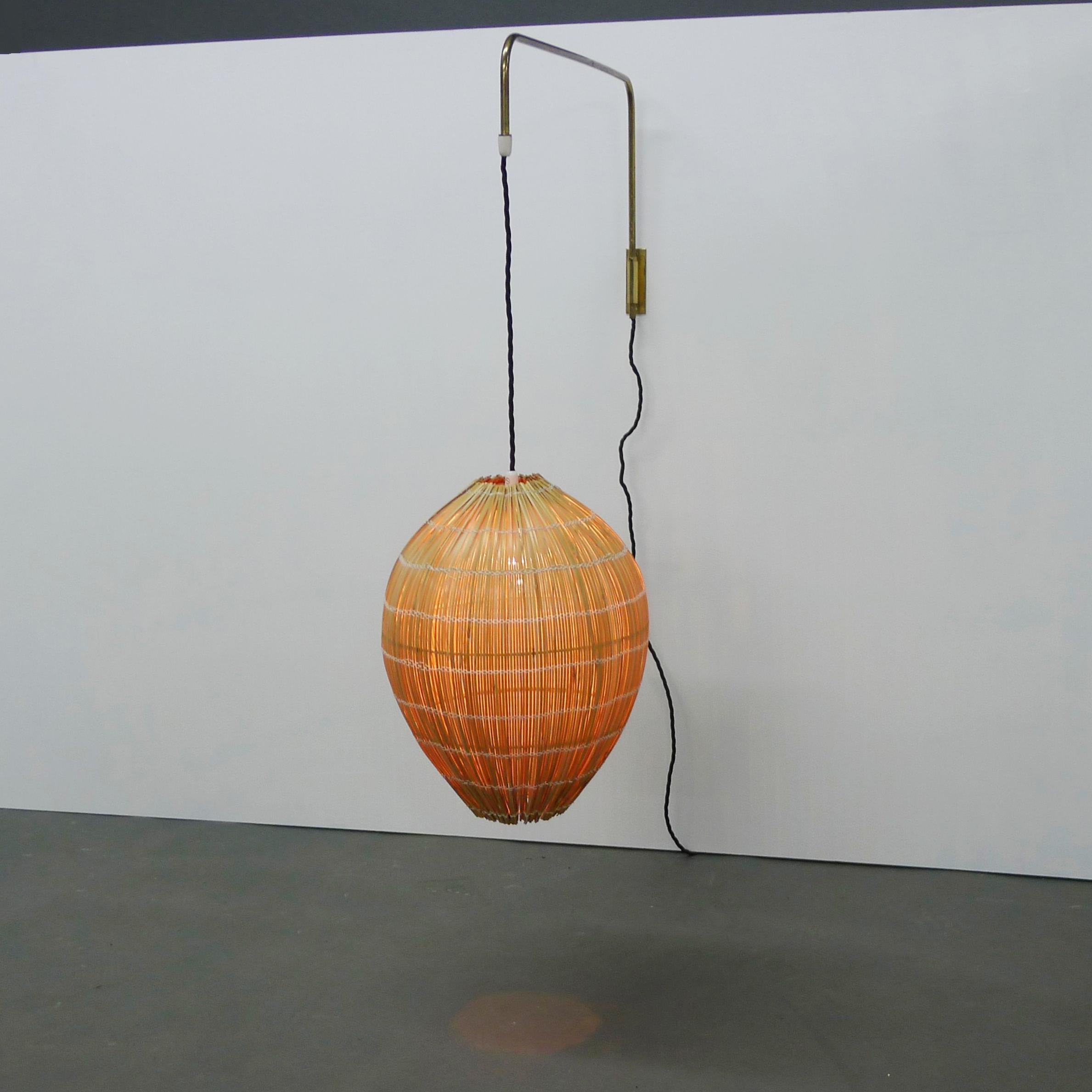 Rare 'Beehive' pendant wall light designed by Paavo Tynell and made by Idman Oy, Vilhonvuorenkatu, Finland, 1940s.

The woven rattan shade is formed in a rigid oval shape by wooden rods, it is suspended with original fabric lead from a tubular brass