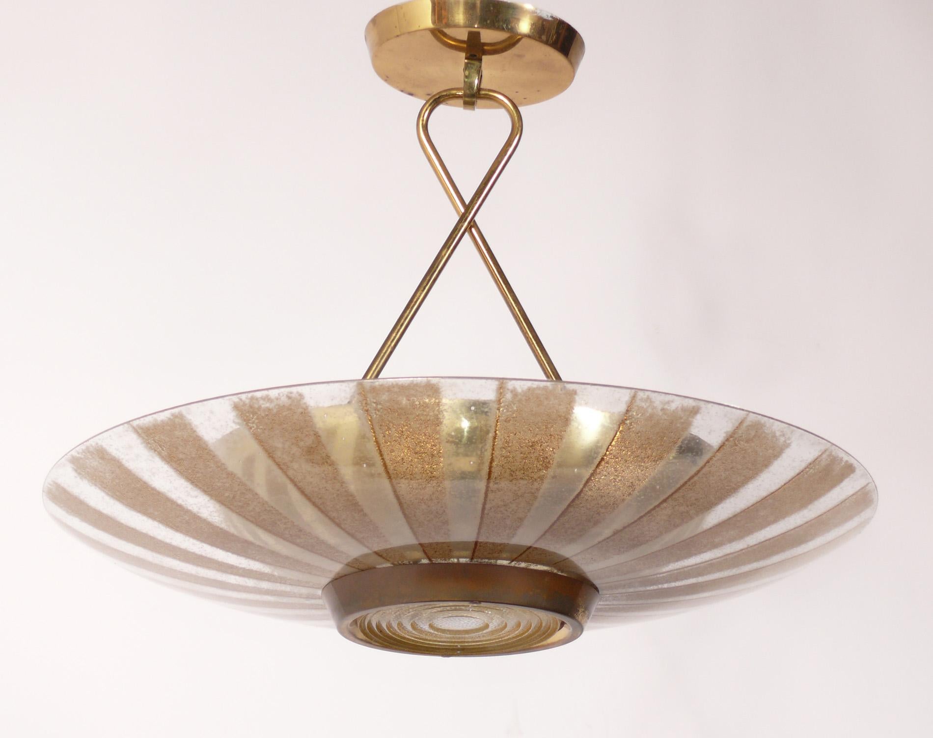 Elegant brass and glass chandelier, the design attributed to Paavo Tynell for Lightolier, circa 1950s. Signed with partial Lightolier label inside original ceiling cap. It has been rewired and is ready to mount. Please see similar Tynell designs