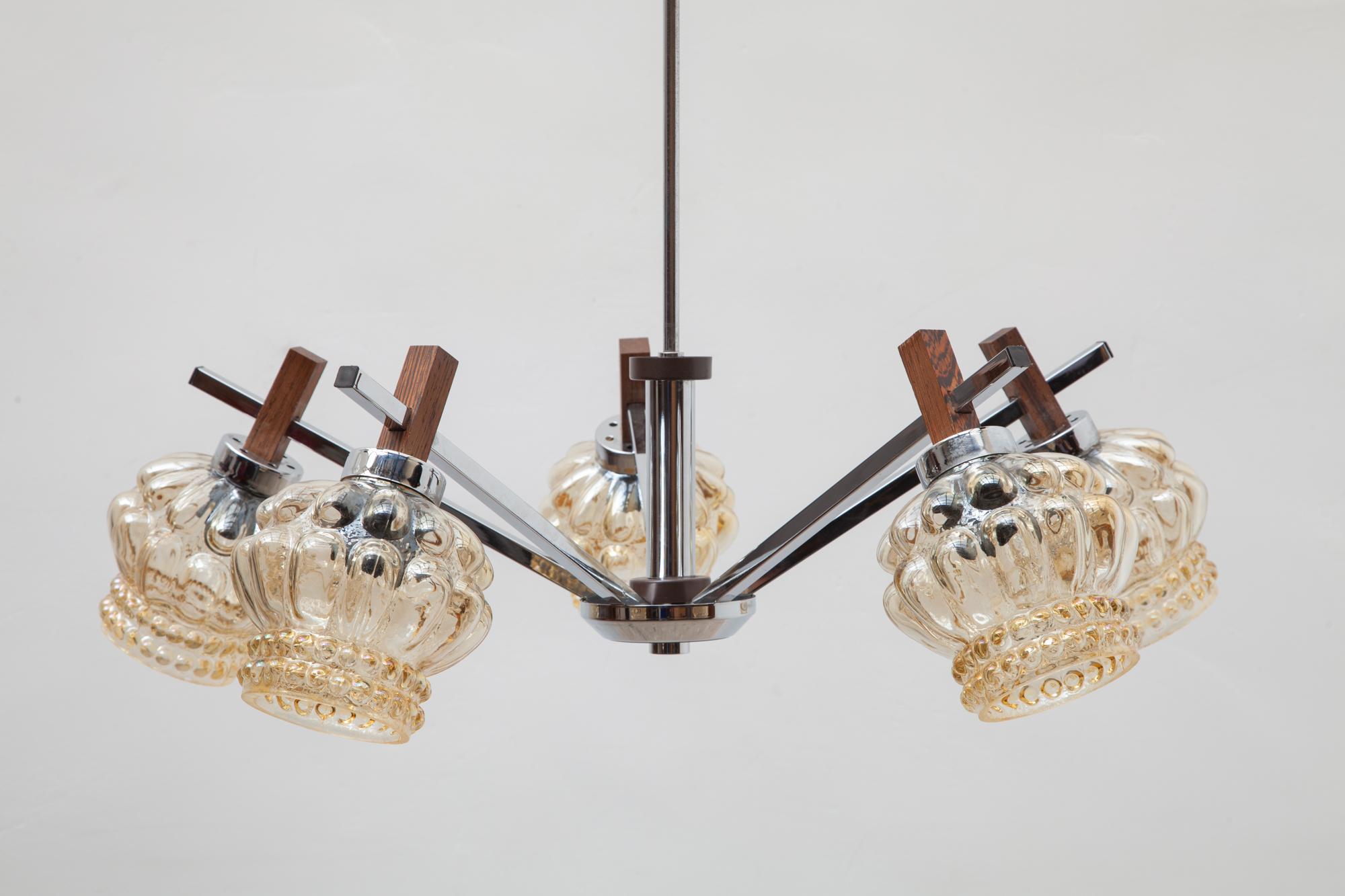 Vintage chandelier by Paavo Tynell for Limburg, Germany. Modern chrome and wood frame with shades of opalescent yellow bubble glass. Lit by 5 bulbs.
Dimension. Chandelier 75 W x 65 H x 75 D cm.