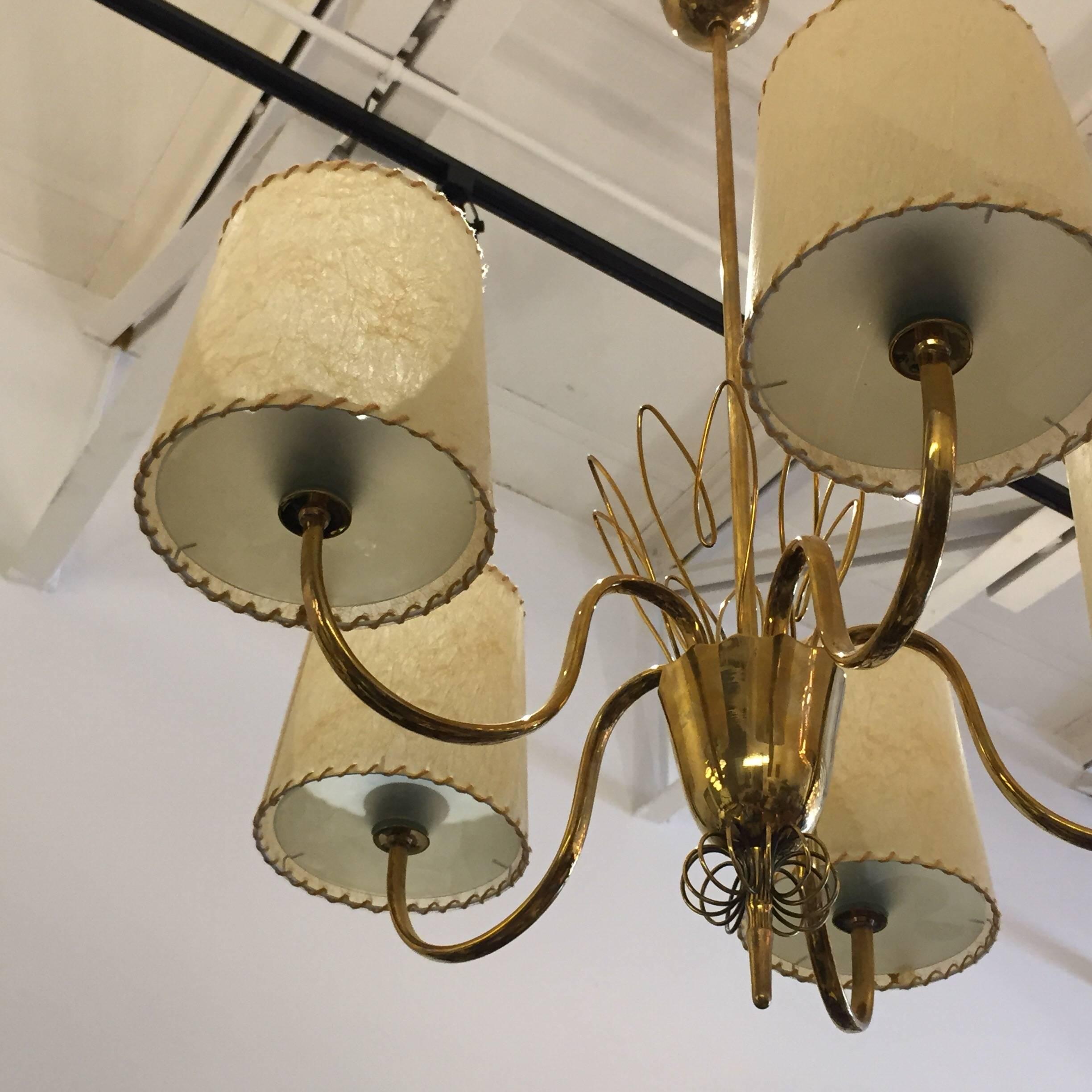 Signed brass chandelier with five lights and original parchment shades designed by Paavo Tynell for Taito, Oy. Modell 9032.