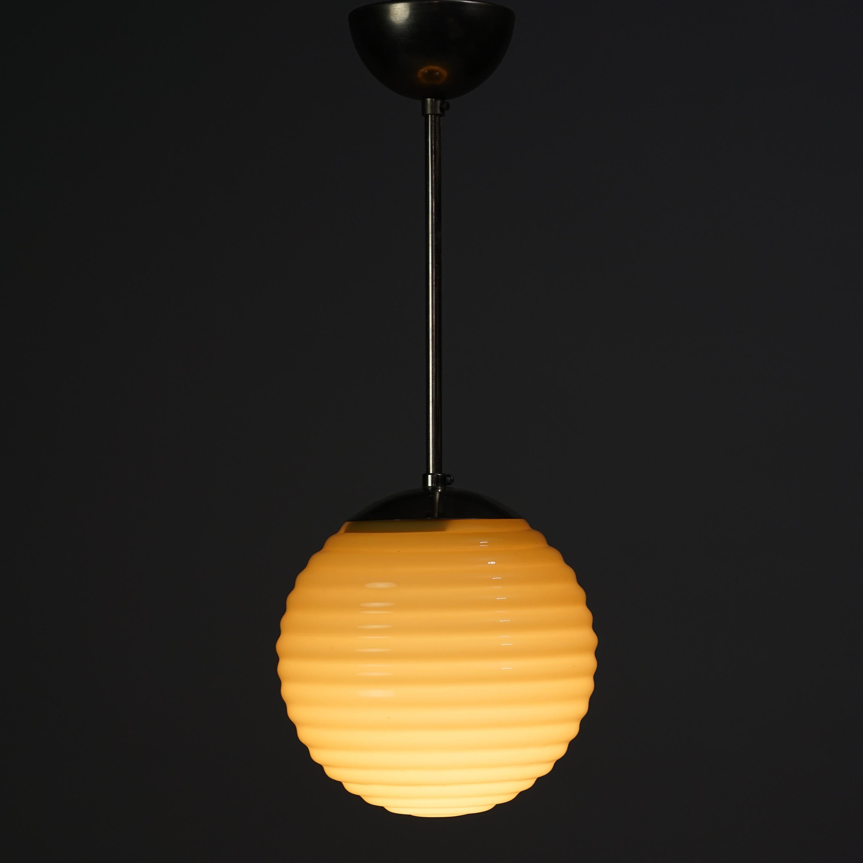 Paavo Tynell glass pendant manufactured by Taito Oy from the 1930s. Opaline glass lampshade, nickel-plated brass frame. Good vintage condition, minor wear consistent with age and use. Classic Scandinavian Modern design from Paavo Tynell.
