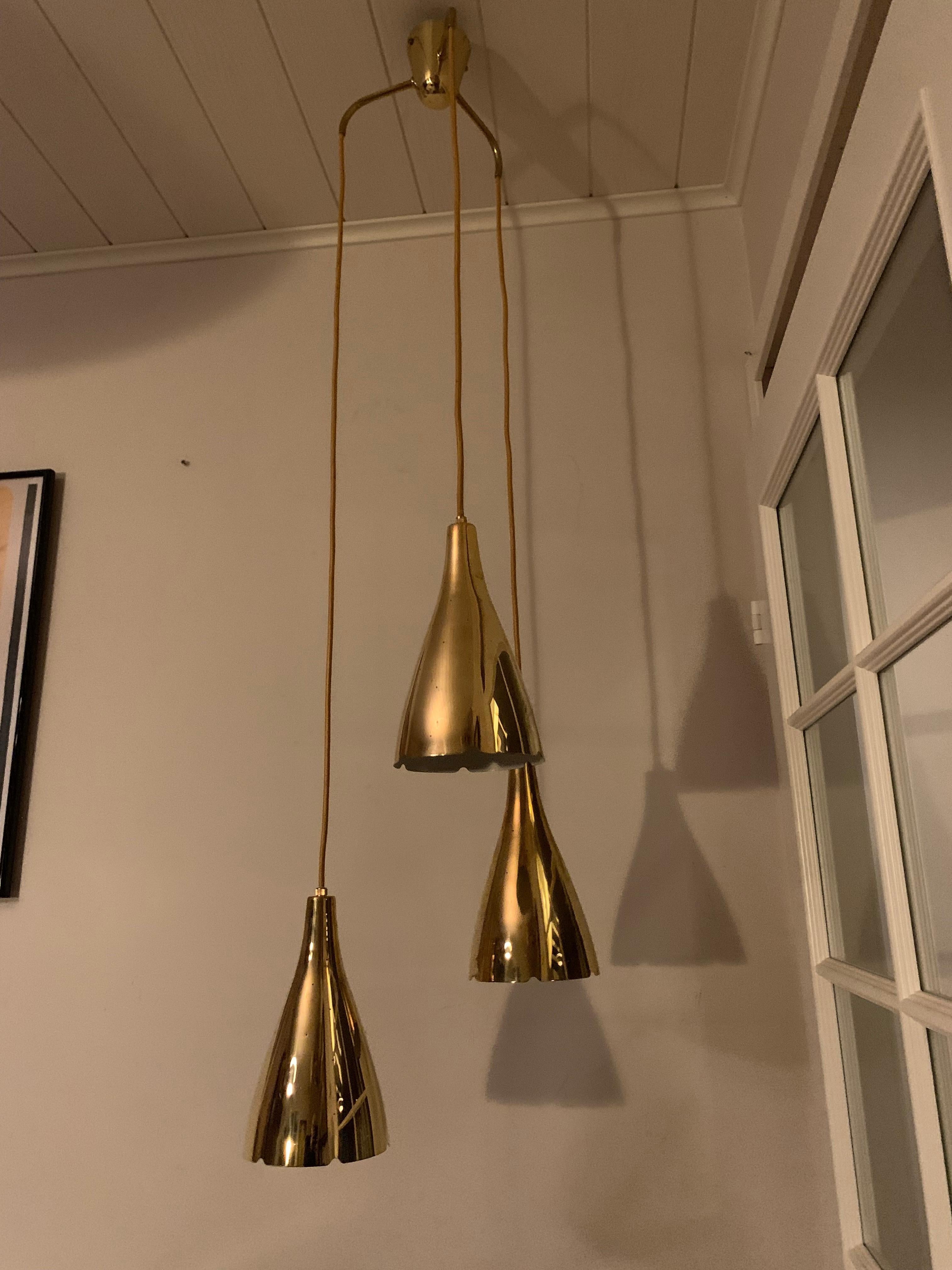 Lampada Model 1994/3 di Paavo Tynell:

Il Model 1994/3 di Paavo Tynell, progettato per Taito Oy in Finlandia intorno al 1953, è una lampada da soffitto di grande effetto. Presenta tre paralumi perforati a forma di cono, dipinti e disposti in modo da
