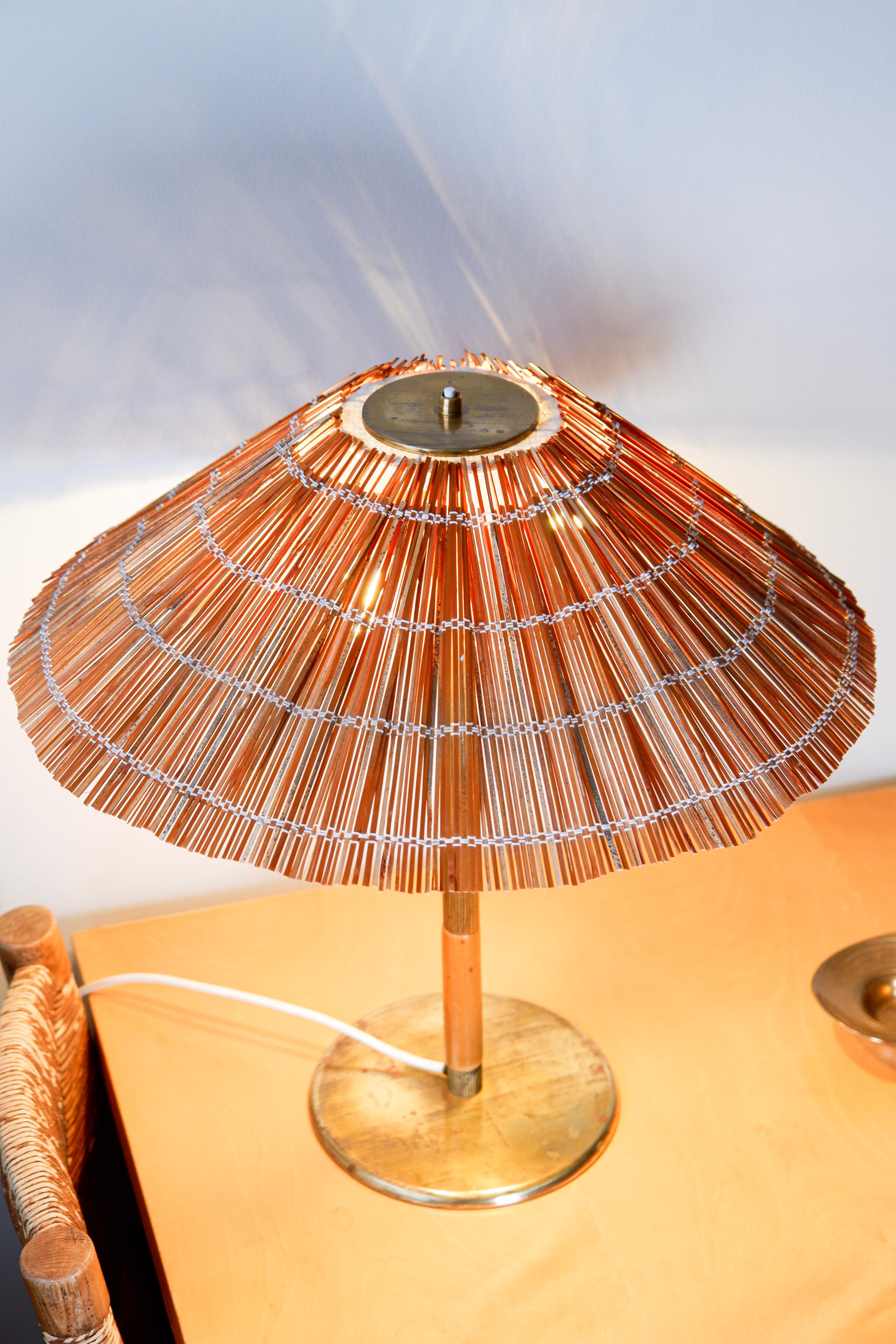 Paavo Tynell Tischlampe Modell 5068 von Taito Oy. Die Lampe ist aus massivem Messing mit einem hölzernen Handel und einem hölzernen Strohschirm hergestellt. Guter Originalzustand, die Lampe ist vom Herausgeber TAito Oy gestempelt. Paavo Tynell ist