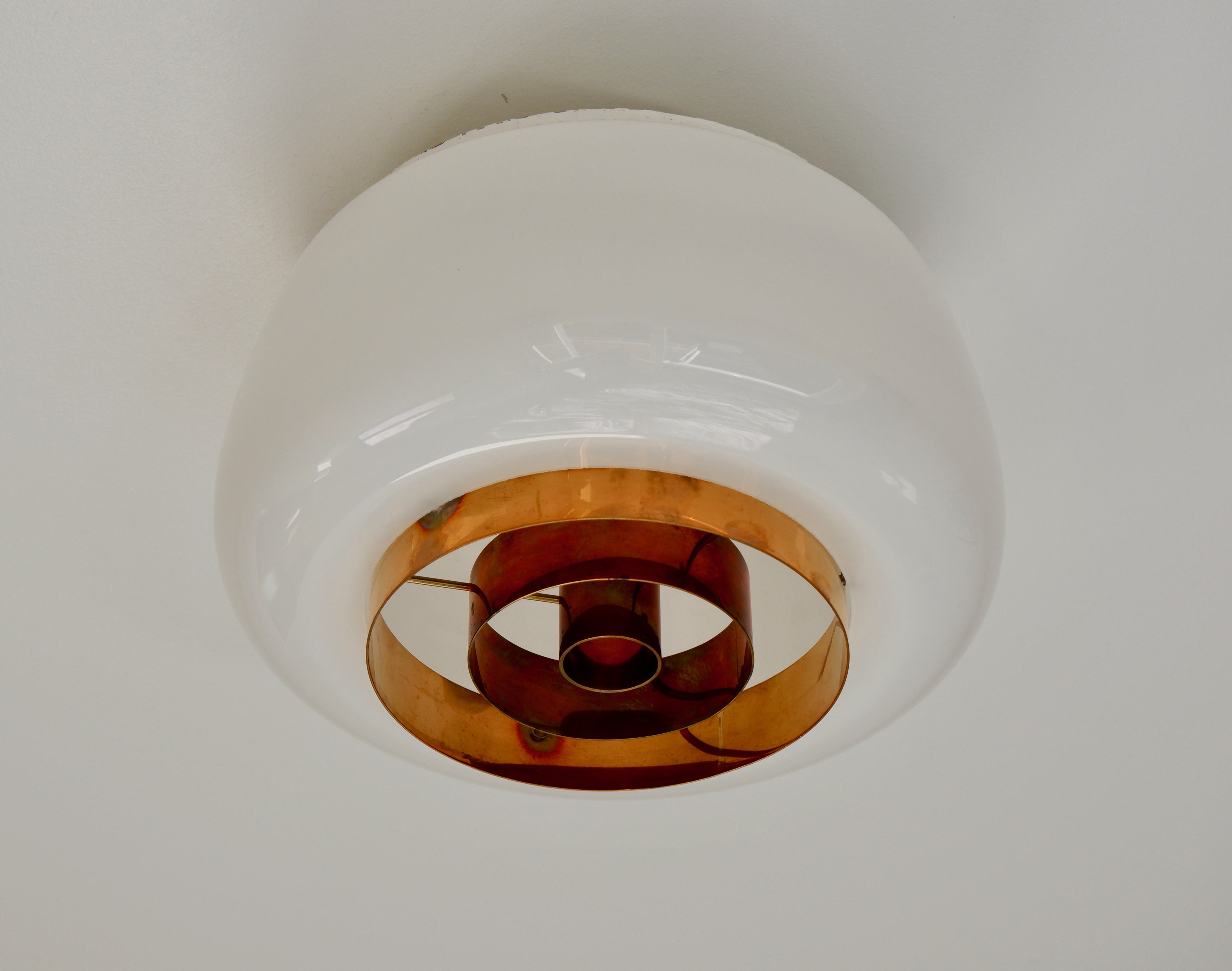 Pair of Ceiling lamps designed by Paavo Tynell for Idman model H2-70. The lamp is composed by an opaline bowl shade and a copper difuseur on the bottom, Both lamps are stamp by the editor Idman. Price per lamp. Could be available by one or as a pair.