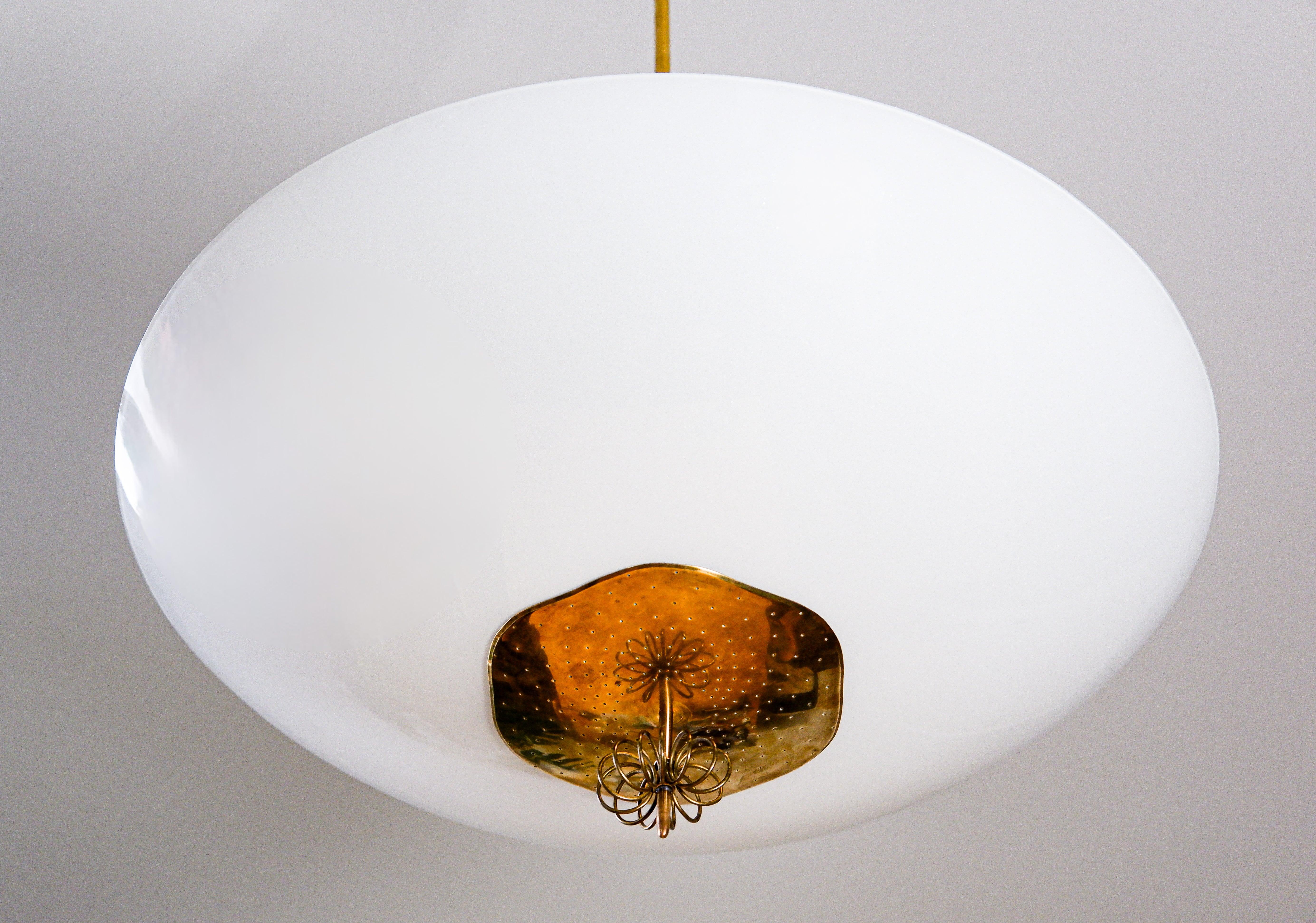Impressive oversized chandelier design by Paavo Tynell and produced by Idamn. The drawing of the lamp is dated by 1949 and the production occured just after that.  The lamp is composed by a large Opal glass ( 59 cm diameter / 23,3 inch  ) and an