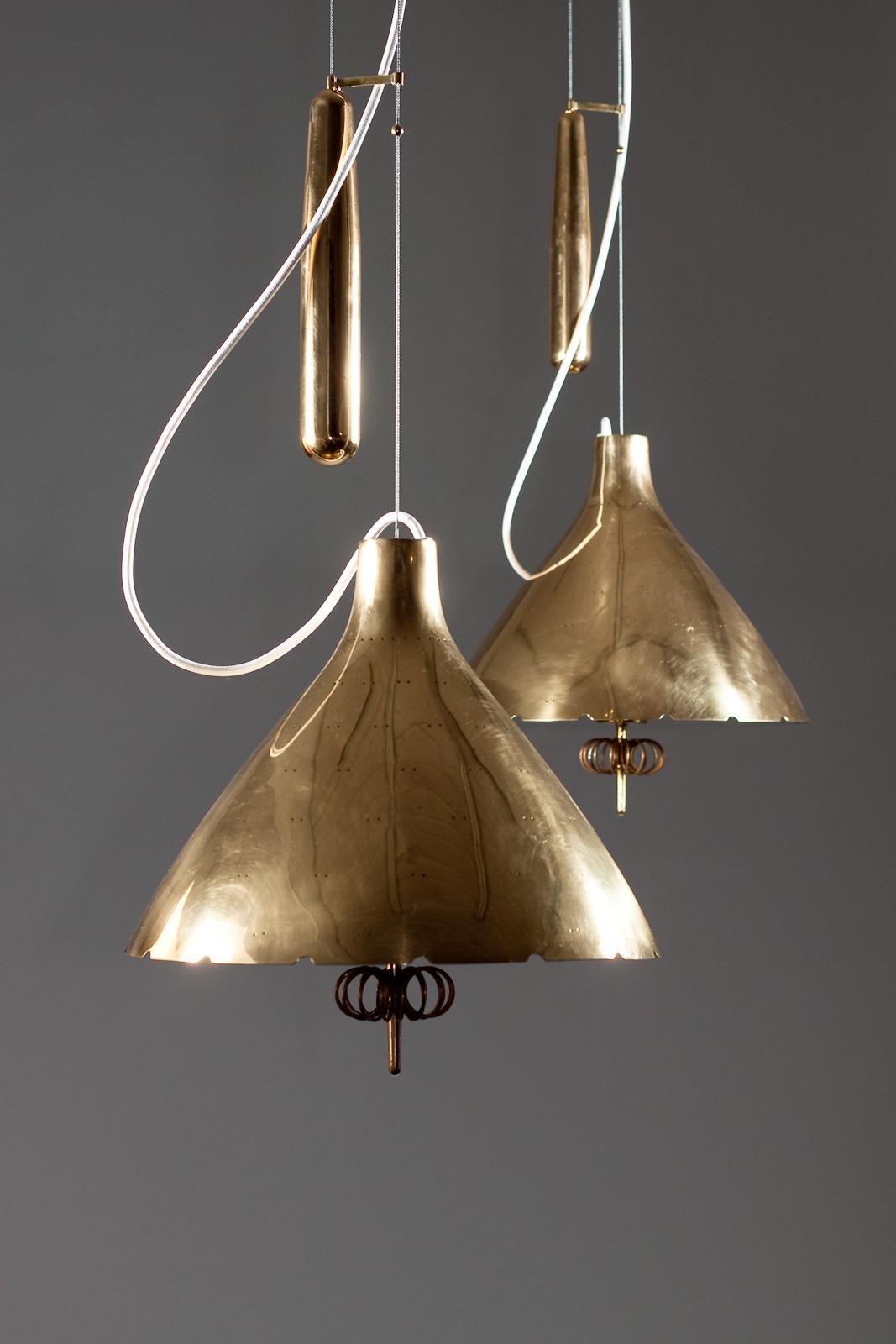 Finnish Paavo Tynell, pair of 1940's brass counterweight pendant lamps, Taito Oy