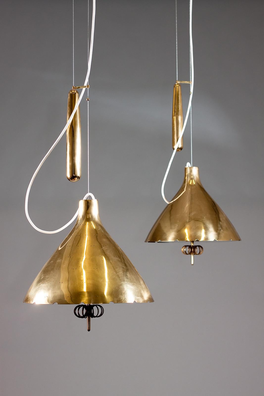 Etched Paavo Tynell, pair of 1940's brass counterweight pendant lamps, Taito Oy