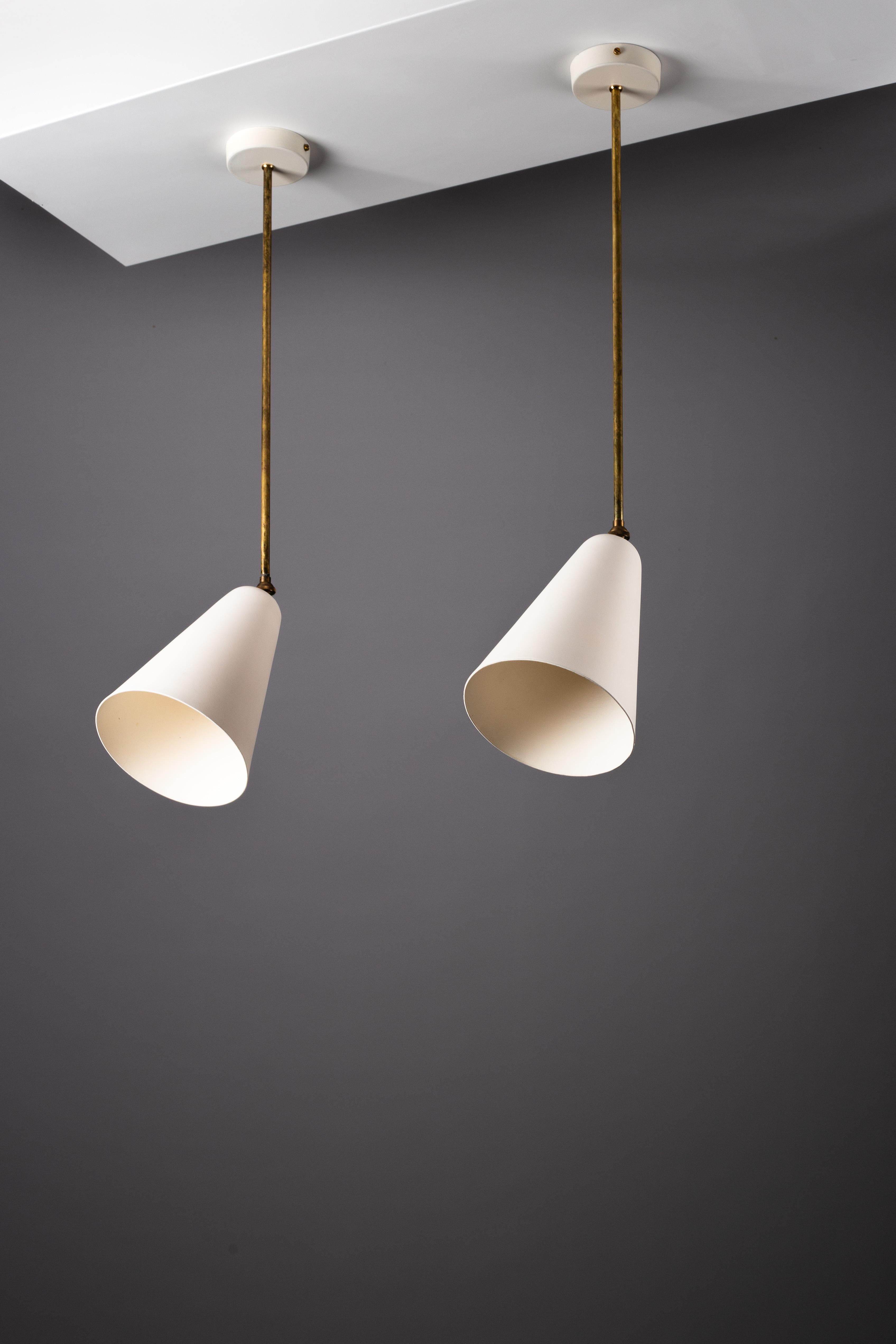 Discover the timeless elegance of this pair of 1950s Paavo Tynell lamps by Idman Oy, featuring an adjustable fixture through brass joints. Perfect for versatile placements, these fixtures can be used as ceiling lights or wall lights, making them