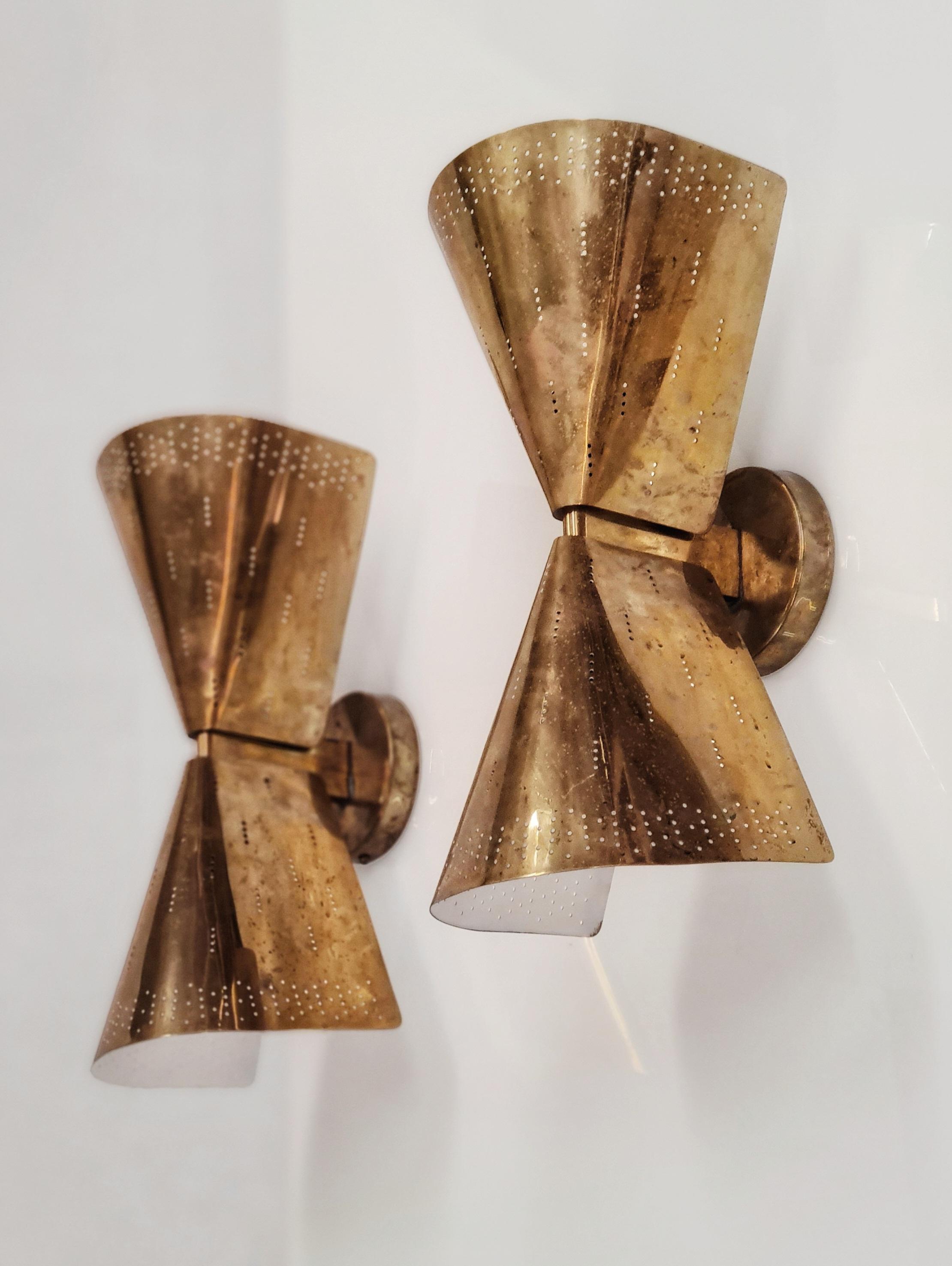 An outstanding pair of Paavo Tynell wall lamps, manufactured by Taito Oy in Finland in the 1950s. This glaring pair of lights is in full brass with minimal details that gives them an amazing appearance when lit up. Both items are in full original