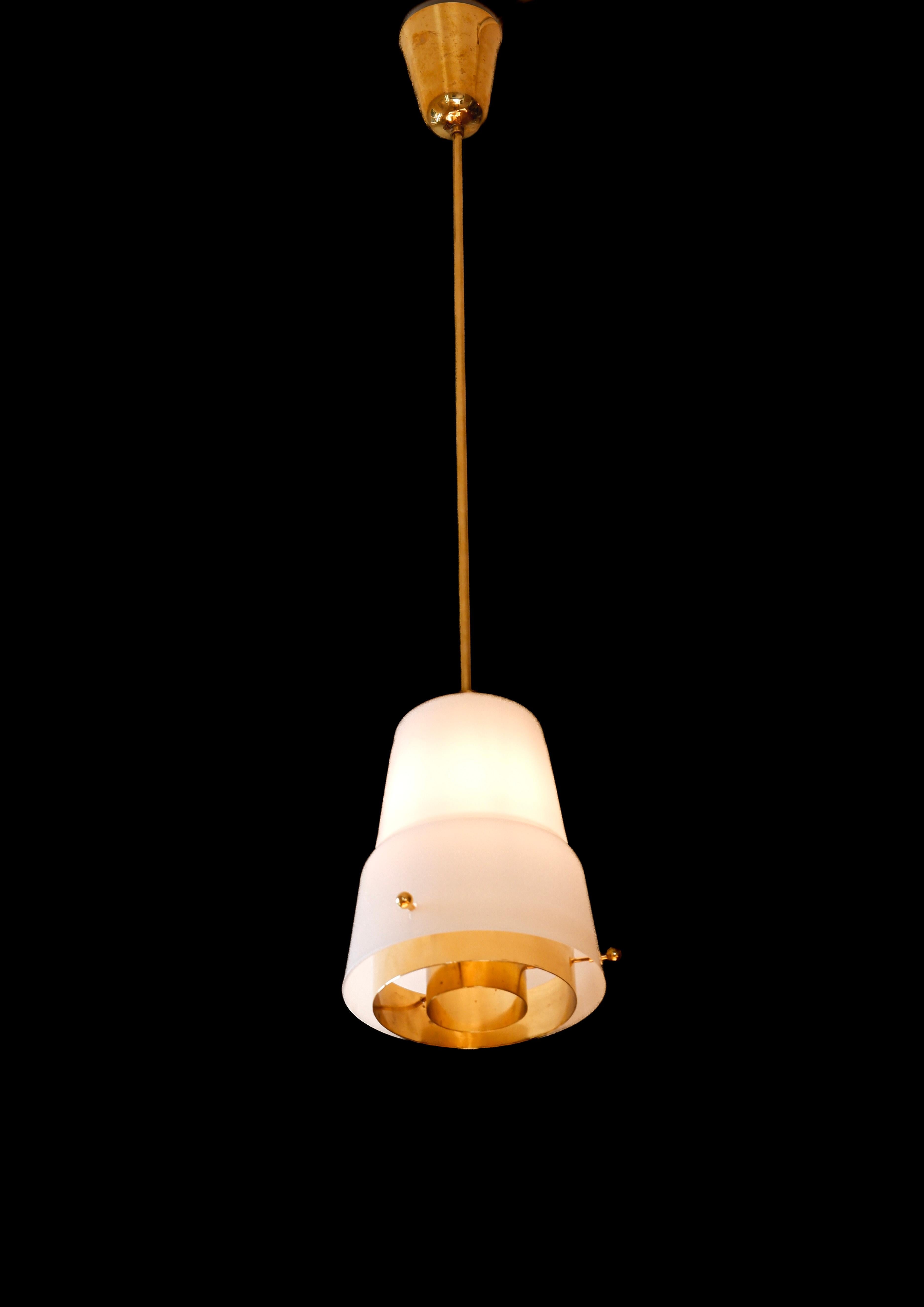 Belle paire de lampes suspendues conçues par Paavo Tynell pour Idman dans les années 50. Les lampes sont fabriquées en verre opale et en laiton avec un diffuseur en laiton massif. Les deux lampes sont estampillées par l'éditeur Idman. Bel état