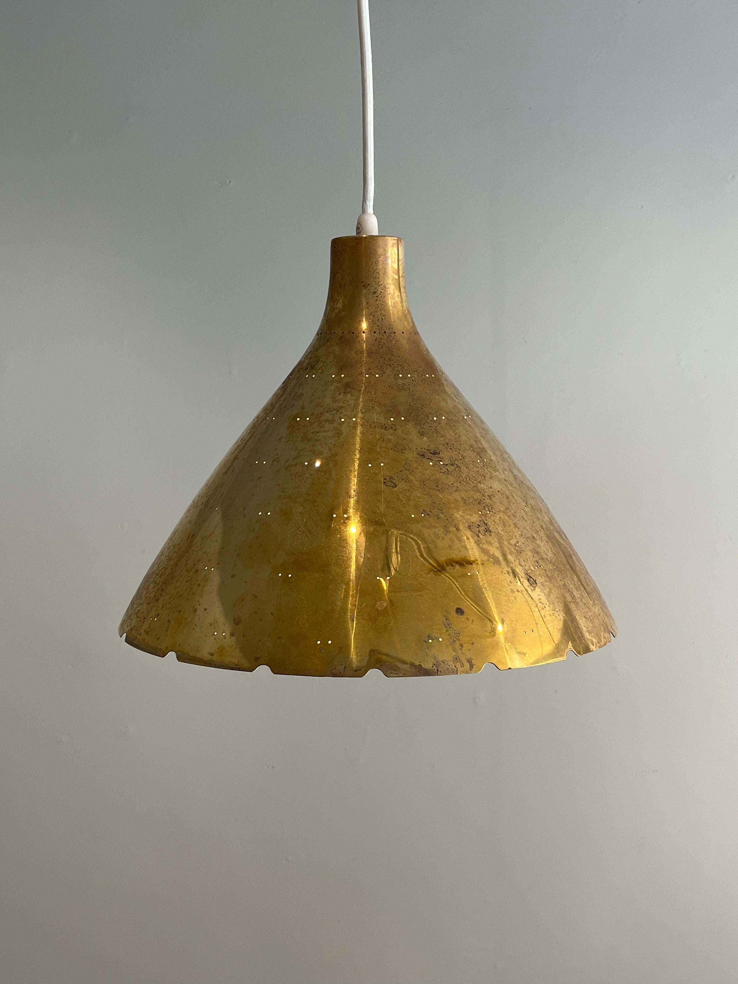 A large edition of the K2-46 brass chandelier by Paavo Tynell by Taito. 
The brass shade has twin dot perforations, scalloped edge detail, and a etched glass diffuser underneath. 
The overall length can be adjusted.
Made by Tiato Oy, Finland,