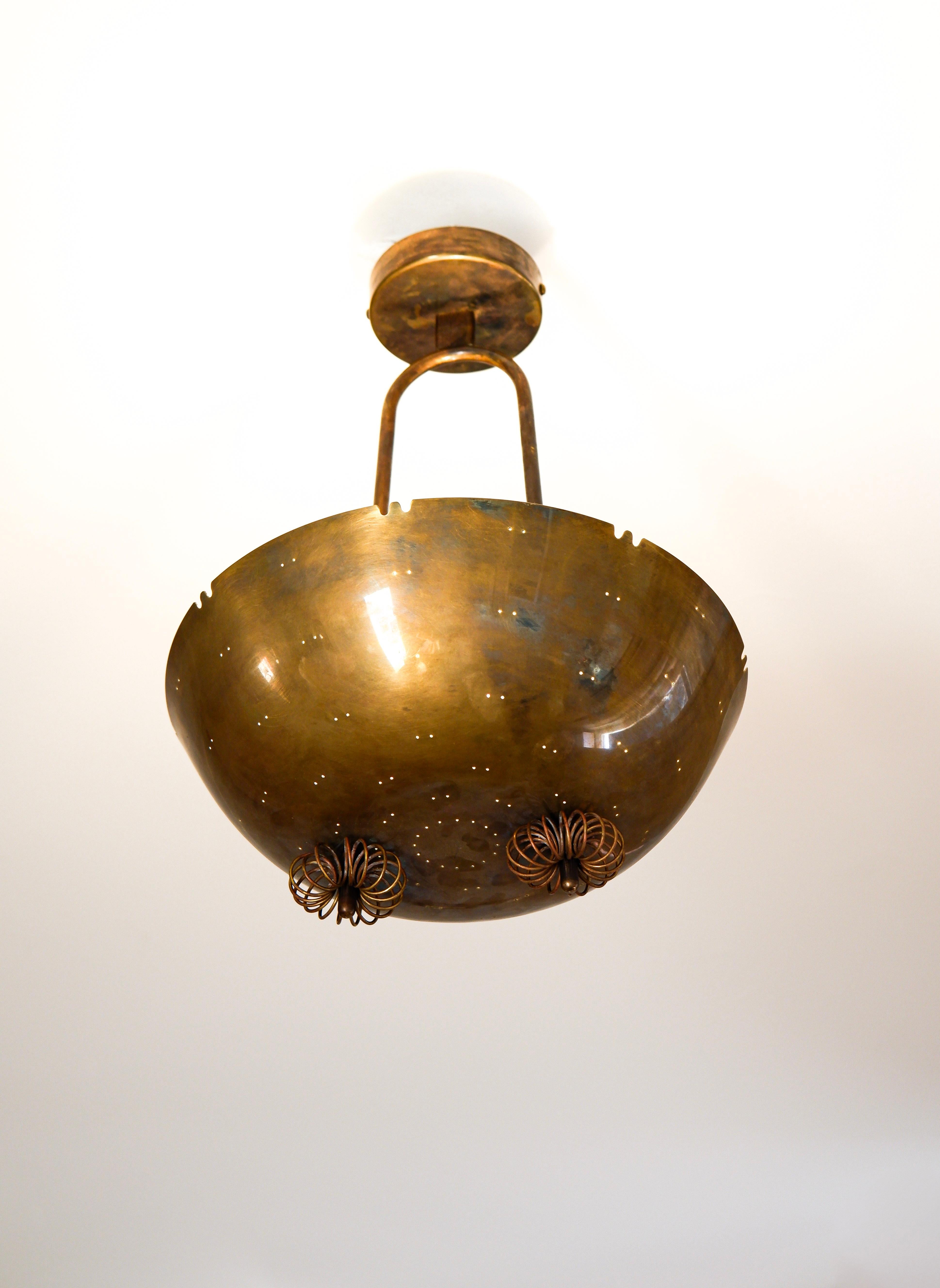 Impressionante lampada a sospensione Paavo Tynell commissionata per un interno.  La lampada è interamente realizzata in ottone massiccio con alcuni anelli di ottone decorati nella parte inferiore. La lampada è realizzata dall'editore Taito e ha un