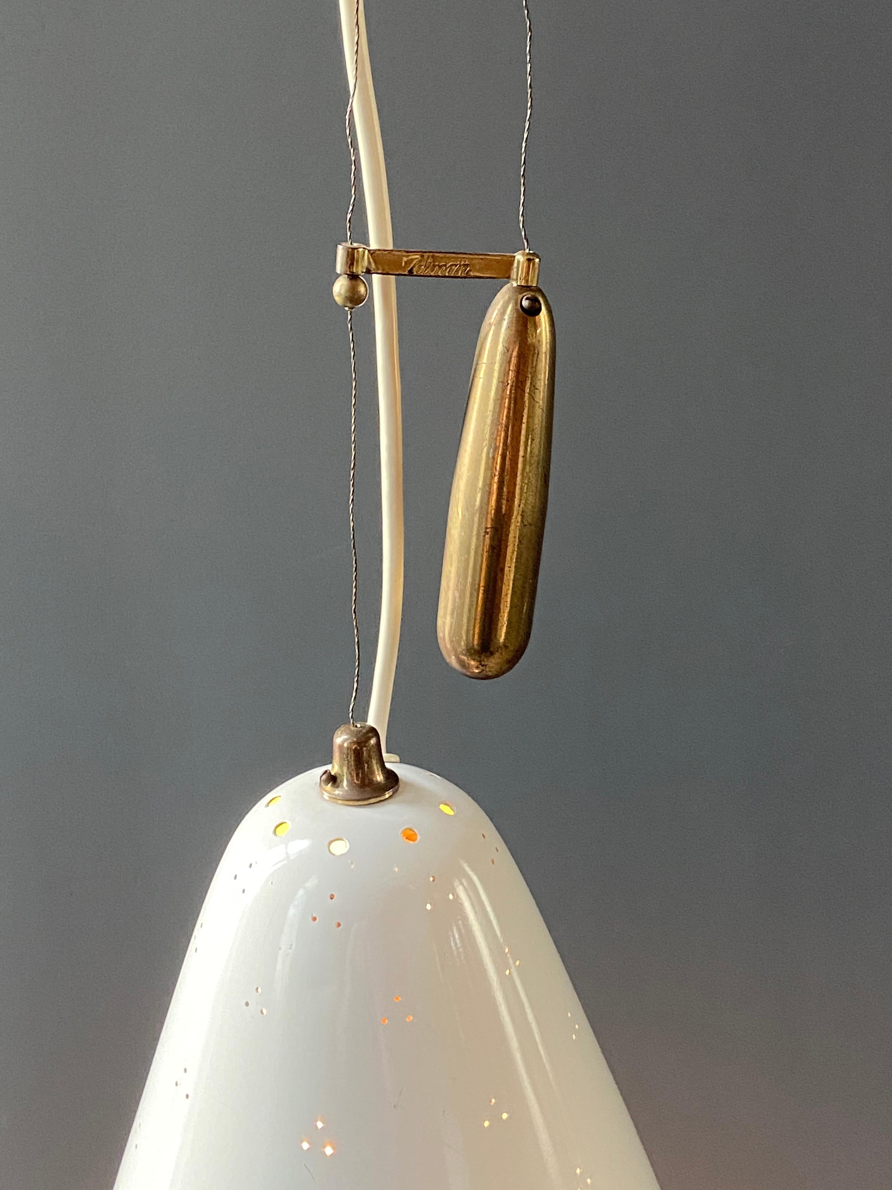 Mid century lighting designer Paavo Tynell's Counterbalance pendant light Model No. A 1942 was made by Idman Oy, circa 1950s. This is an adjustable ceiling light made of a brass canopy and counterweight with a white enameled metal bell shaped