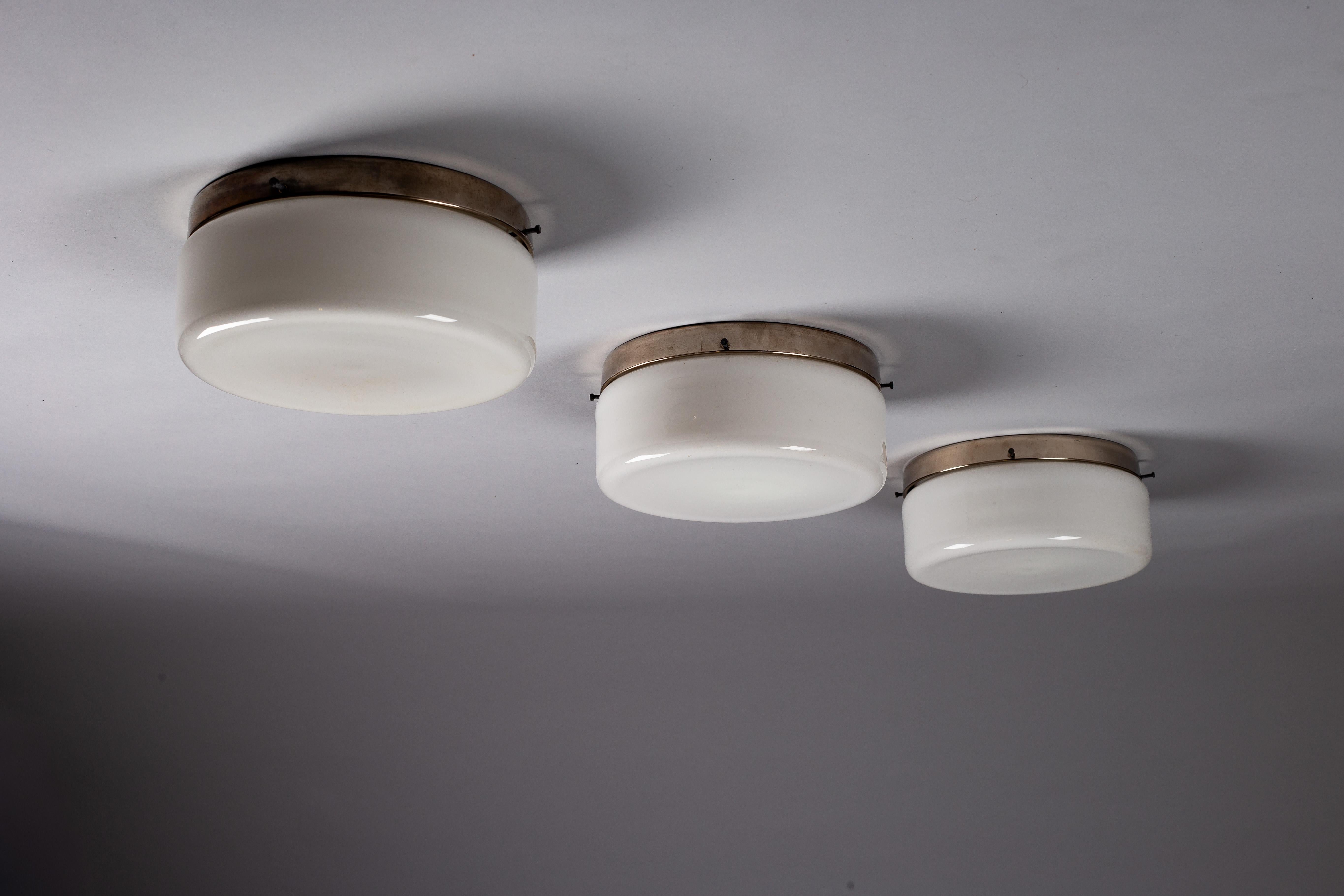 Mettez en valeur votre intérieur grâce à l'élégance intemporelle de l'ensemble Paavo Tynell, composé de trois affleurements en verre opalin des années 1930,  produit par Taito Oy. Ces trésors vintage scandinaves offrent une utilisation polyvalente,