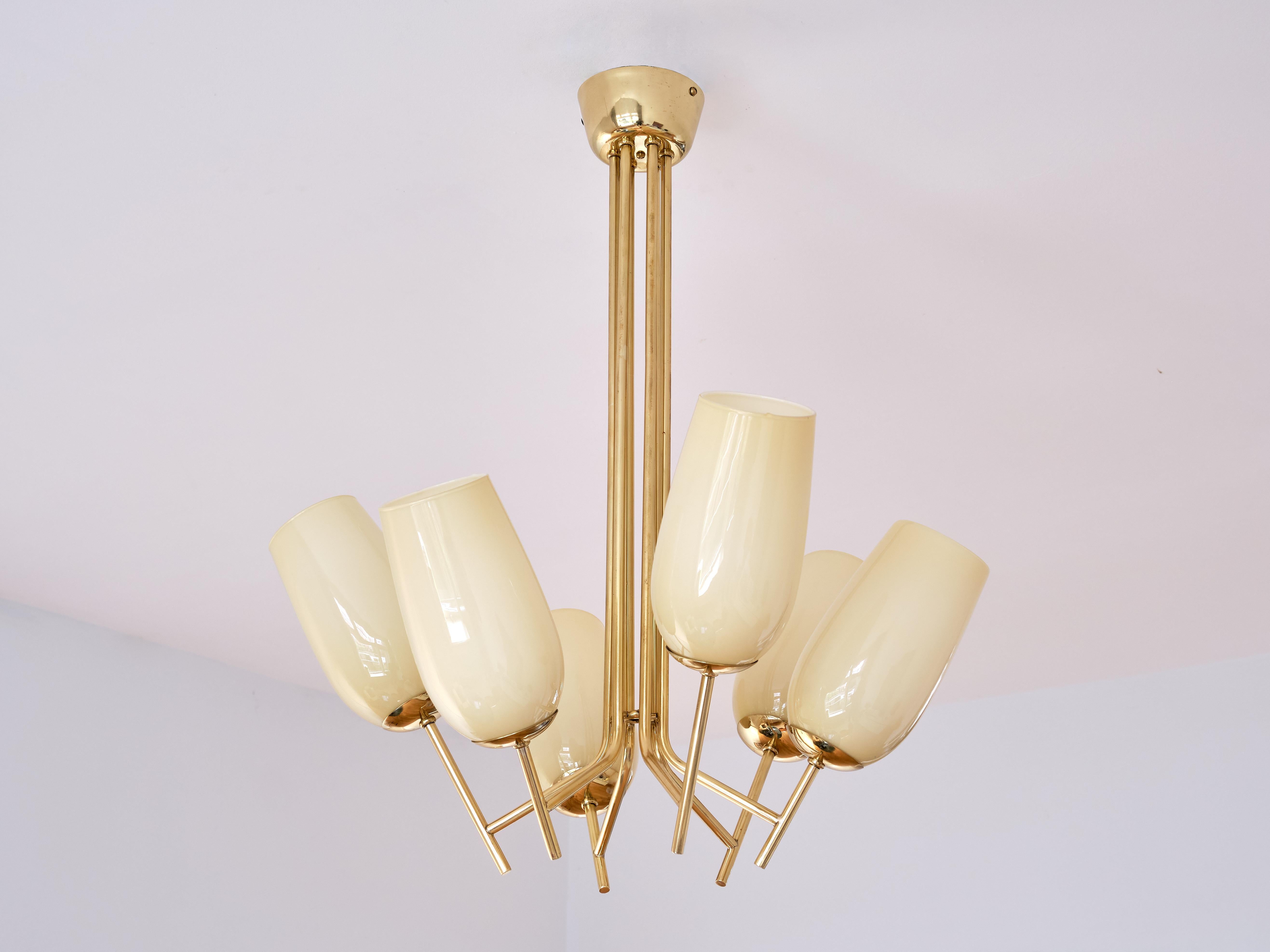 This exceptionally rare chandelier was designed by Paavo Tynell and produced by Taito Oy in Finland in the 1940s. The elegant fixture consists of six individual brass arms coming together in the centre and leading up to the brass canopy. The six