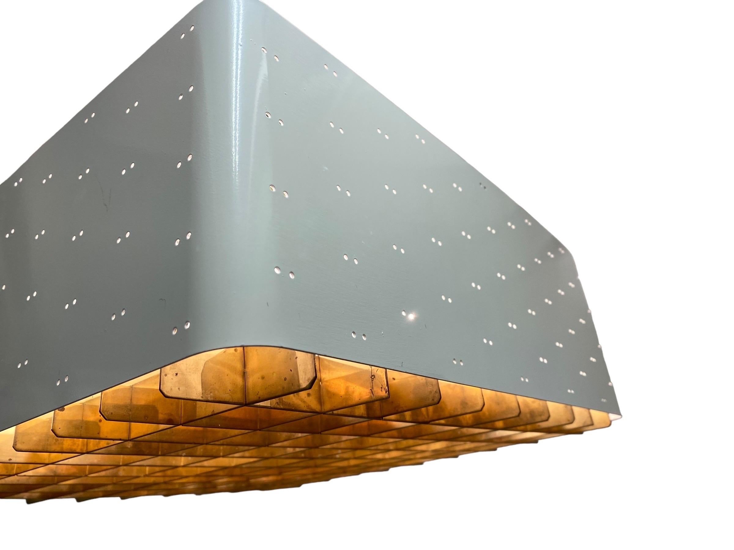 The Starry Sky is one of the most iconic designs of Paavo Tynell's lamps. It was made by both Taito and Idman in many different sizes. The way the light filters through the grill and the holes on the sides makes the ceiling look like a starry sky.