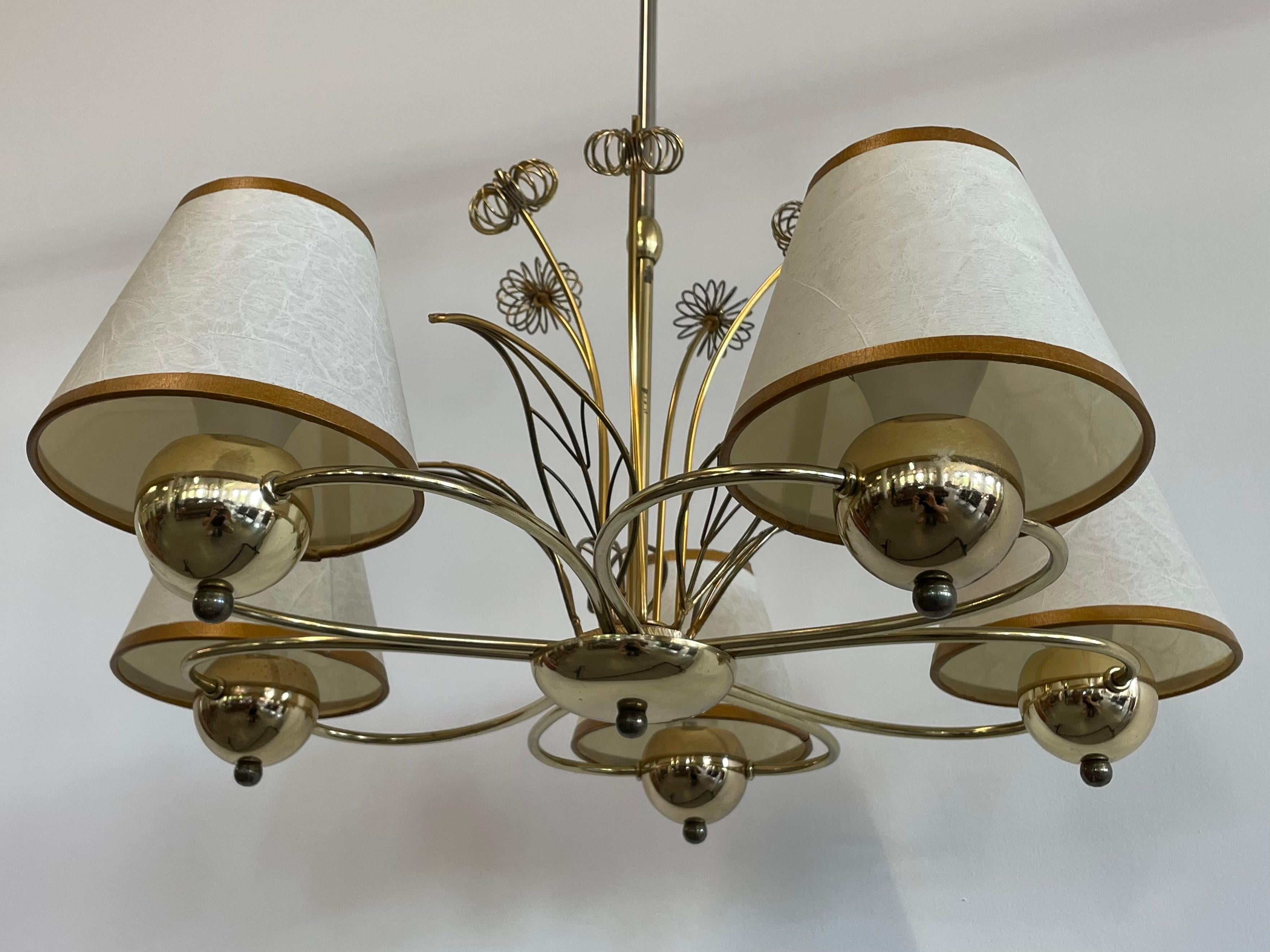 Stunning and unique brass chandelier in the style of Paavo Tynell by Lightolier. This piece sculptural floral elements characteristic of Tynell designs. It provides nicely diffused light through  original textured paper shades.  Measures 21” W x 11”