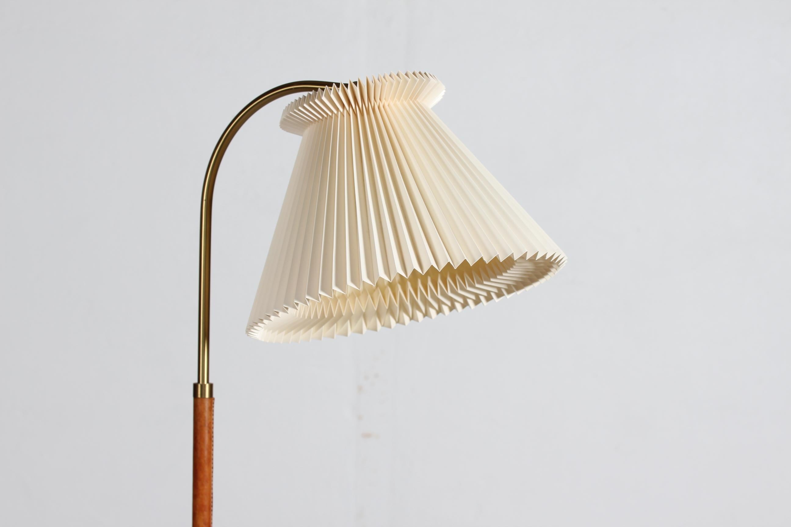 Danish lightning design, floor lamp from the 1950´s with Le Klint lamp shade.

The floor lamp is made of brass with strong cognac colored leather winding. The height of the lamp and the angle of the lamp shade i adjustable.

Measures: Height