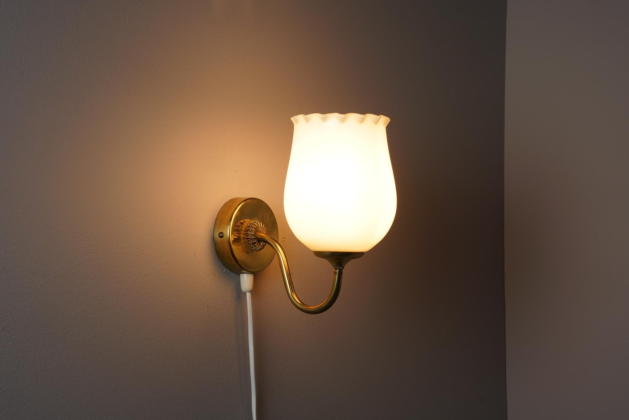 Paavo Tynell -style Scandinavian modern wall light by Itsu Finland from the 1940/1950s. The brass frame is manufactured by Itsu and the opaline glass shade manufactured by Idman Oy. Beautiful craftmanship. Classic piece of Scandinavian modern light.